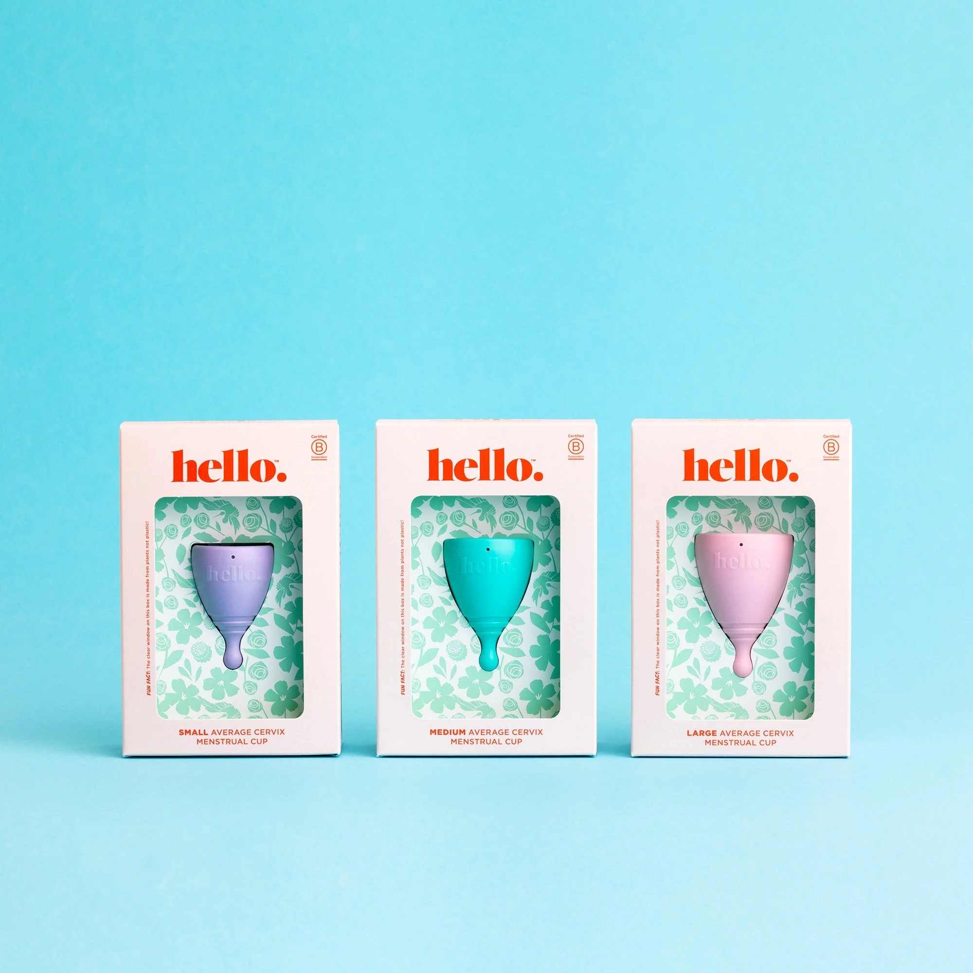 Hello Period reusable menstrual cups in lilac, green and pink. Packaging shown on blue background. Studio photography, packaging design, branding, typography, designer. Alice Lloyd.