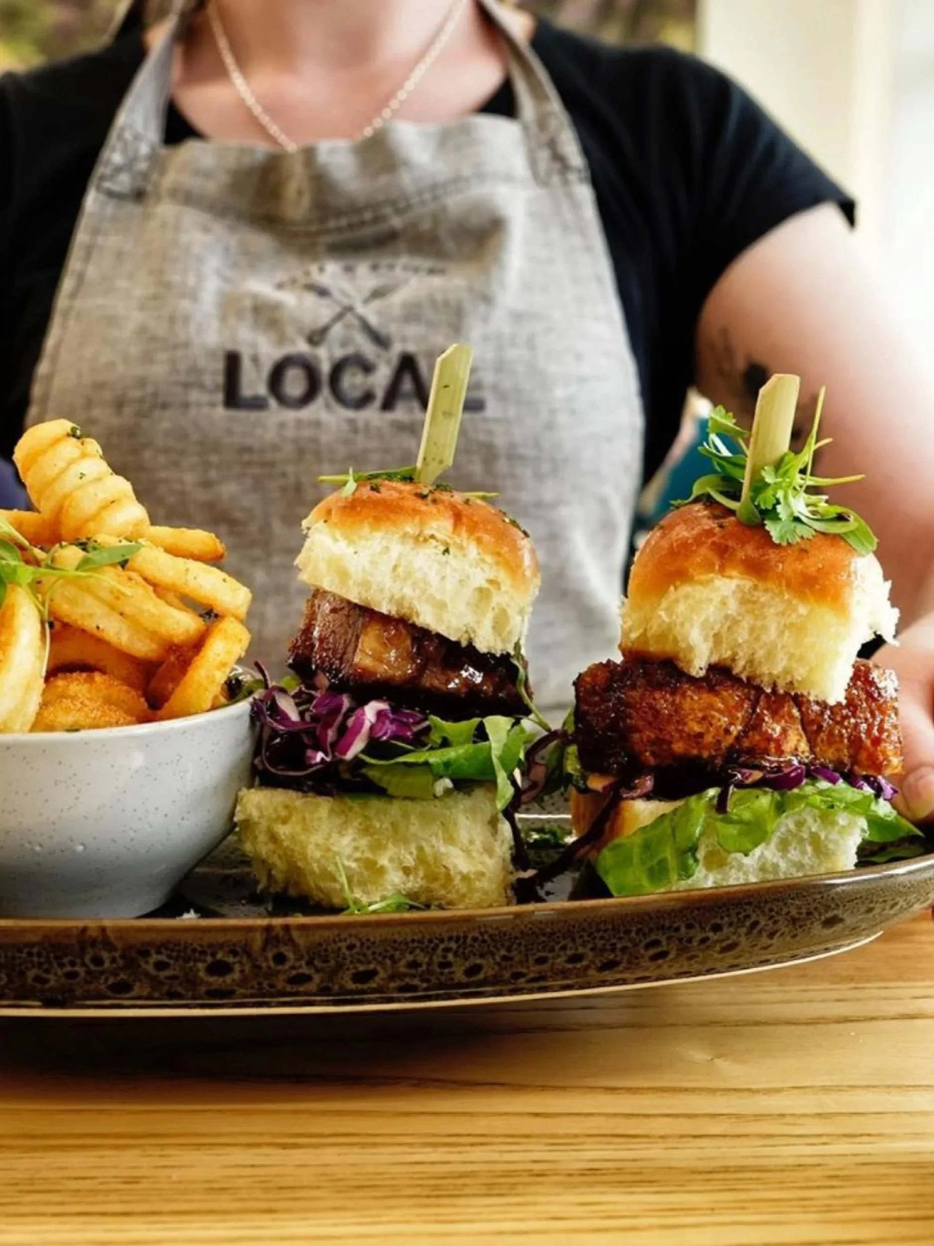 Local cafe and eatery food being presented by staff member in Local branded apron. Branding, hospitality design, interior architecture, designer, Creative Director. Alice Lloyd.