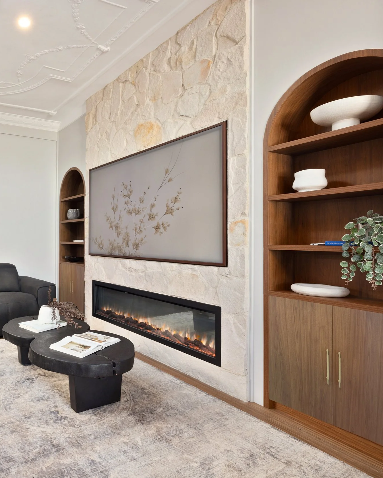 Electric fireplace, sandstone wall, integrated shelving, walnut