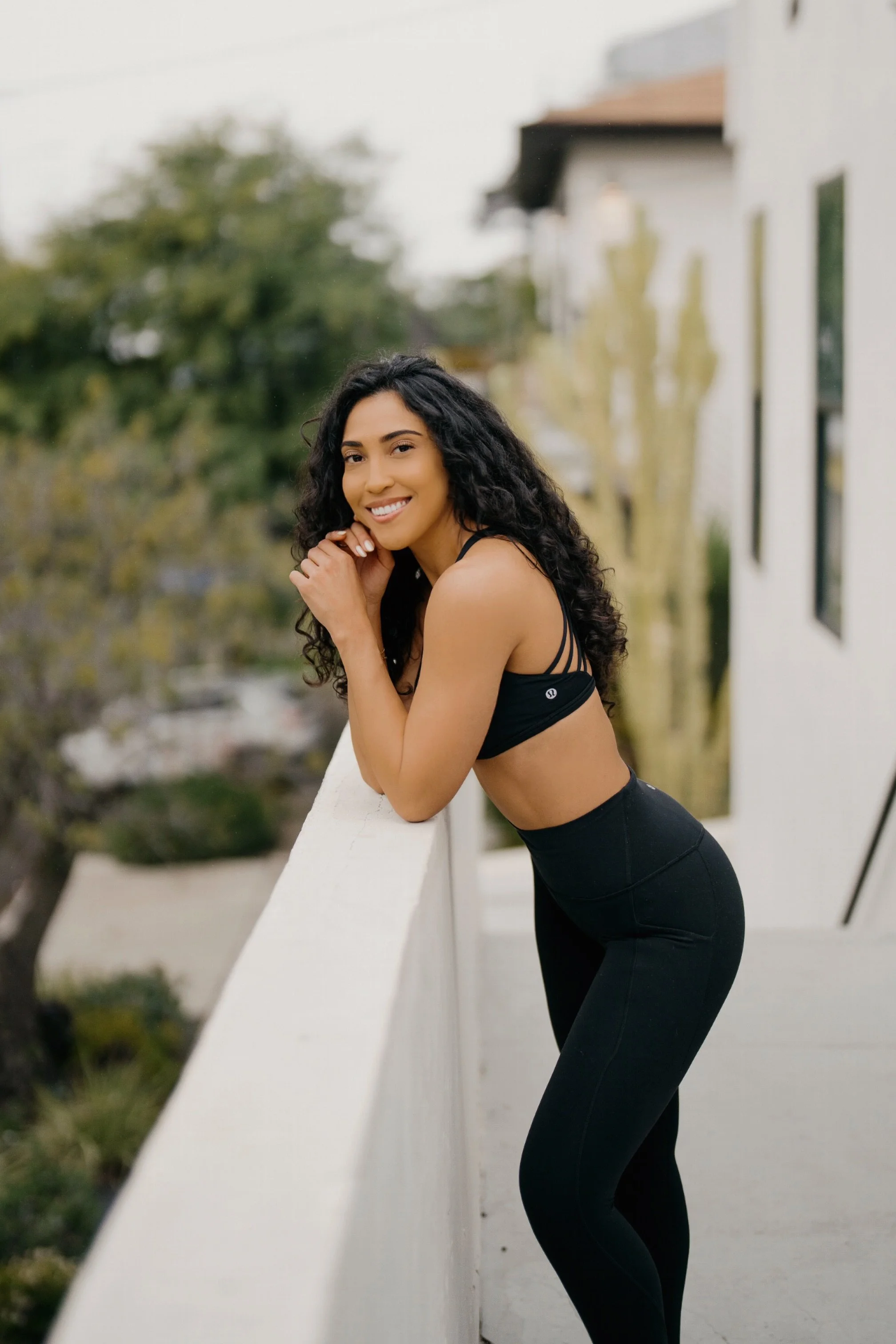 Angie, ALGNMNT fitness and wellness coach, smiling in athletic wear