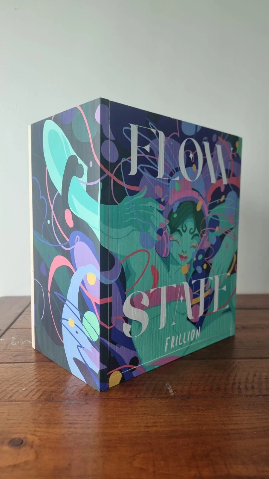 A colorful card with abstract art, featuring the words 'LOVE', 'STICK', and 'FRICTION' on the front.