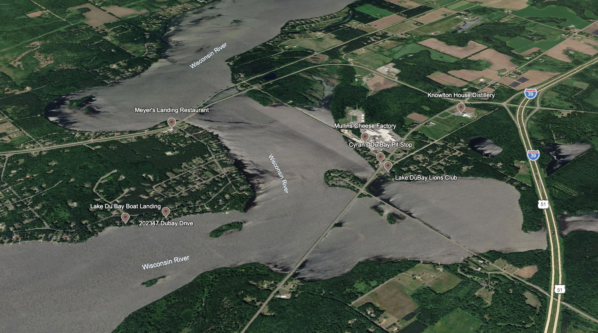 Aerial view of Wisconsin River with surrounding landscape including farms, roads, and landmarks such as Meyer's Landing Restaurant, Mullins Cheese Factory, Cyan's Du Bay Pit Stop, Lake Du Bay Boat Landing, Knowlton House Distillery, and Lake Du Bay Lions Club, with highways 39 and 51 visible.