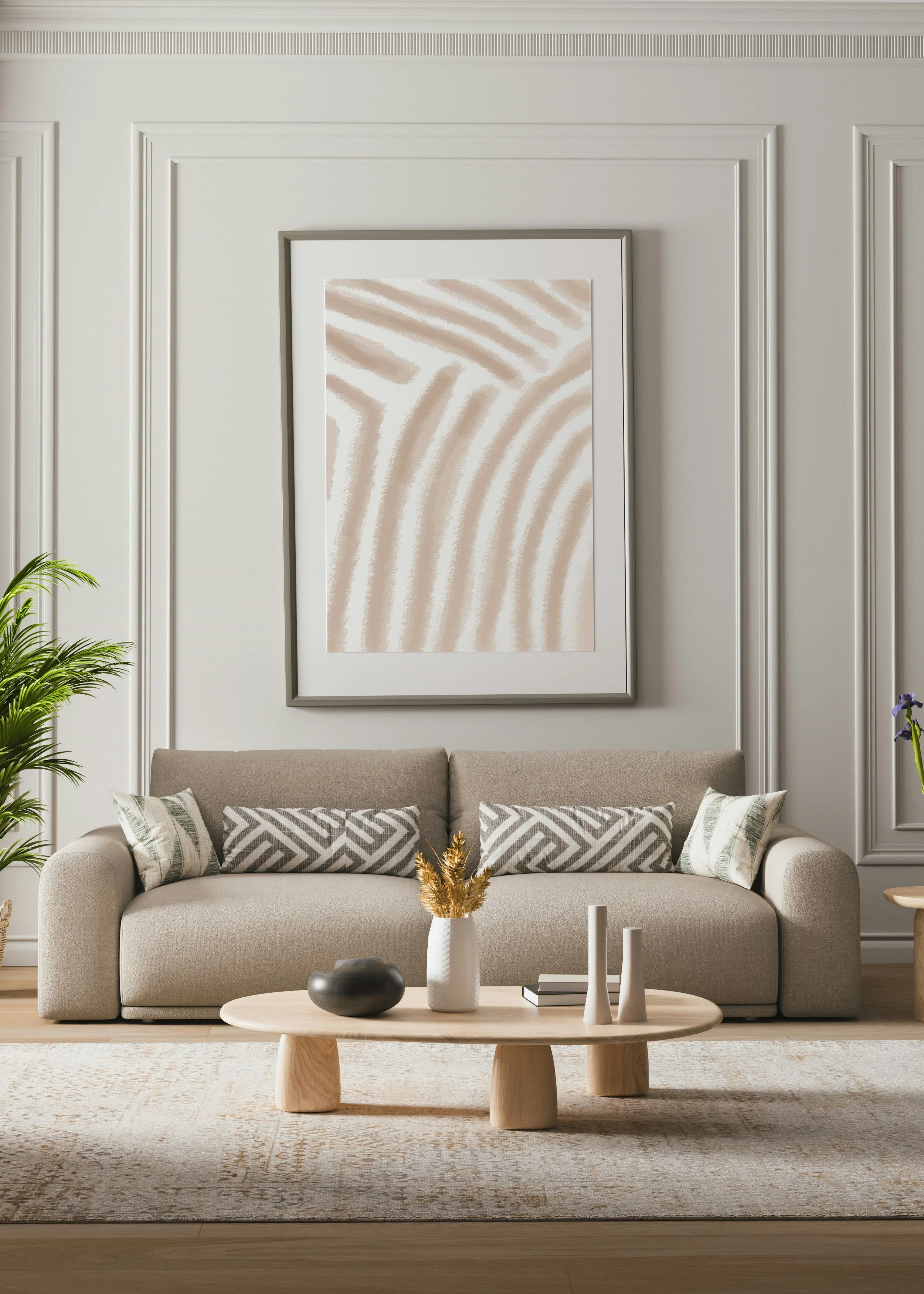 A beige sofa with patterned cushions in front of a decorative wall with white panel molding and a large abstract art piece. A light wooden coffee table with vases and decorative objects is in the foreground, with a plant visible on the left side.