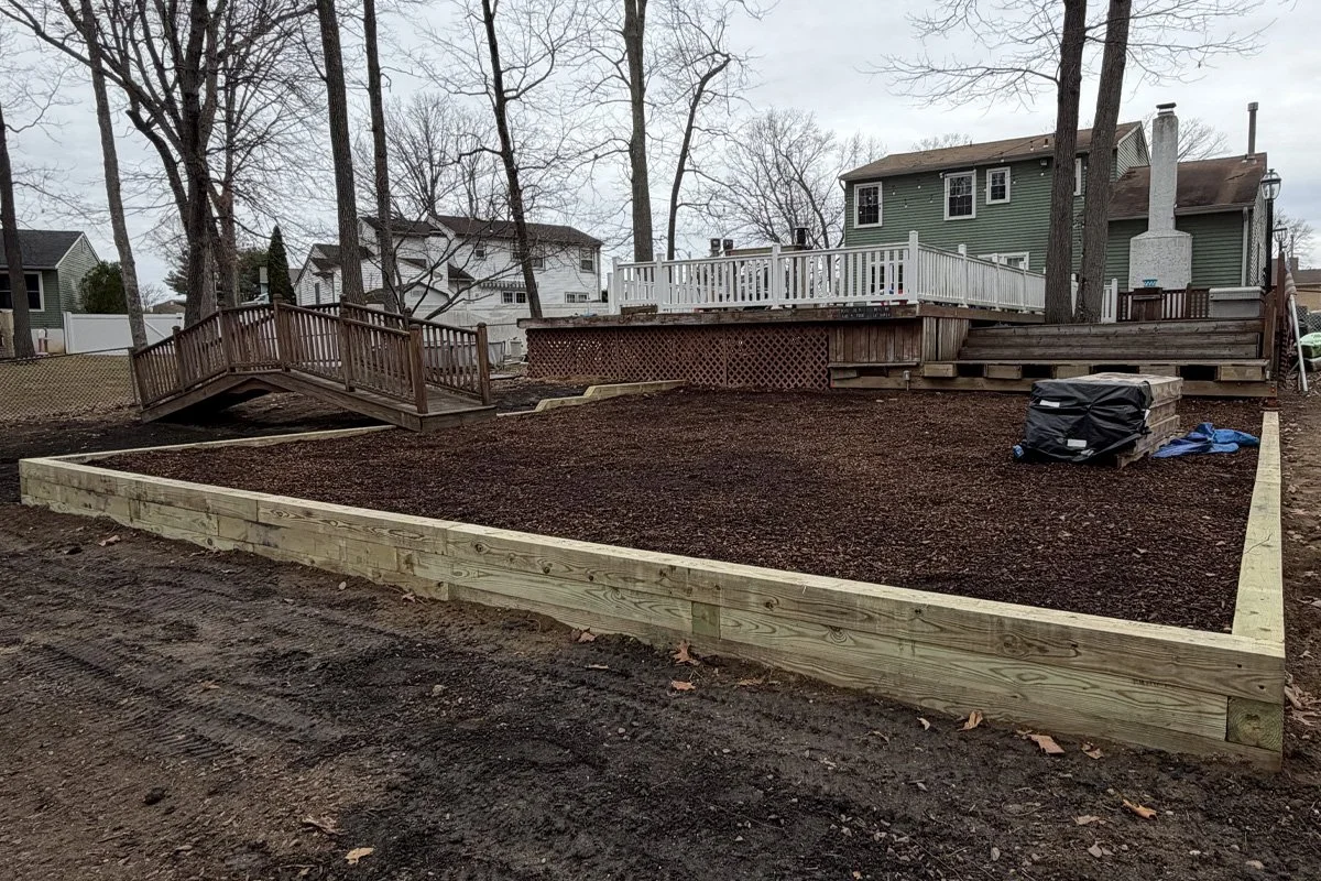 A 6x6 timber retaining wall to create usable outdoor space for a swing set and play area in Washington Township, NJ.
