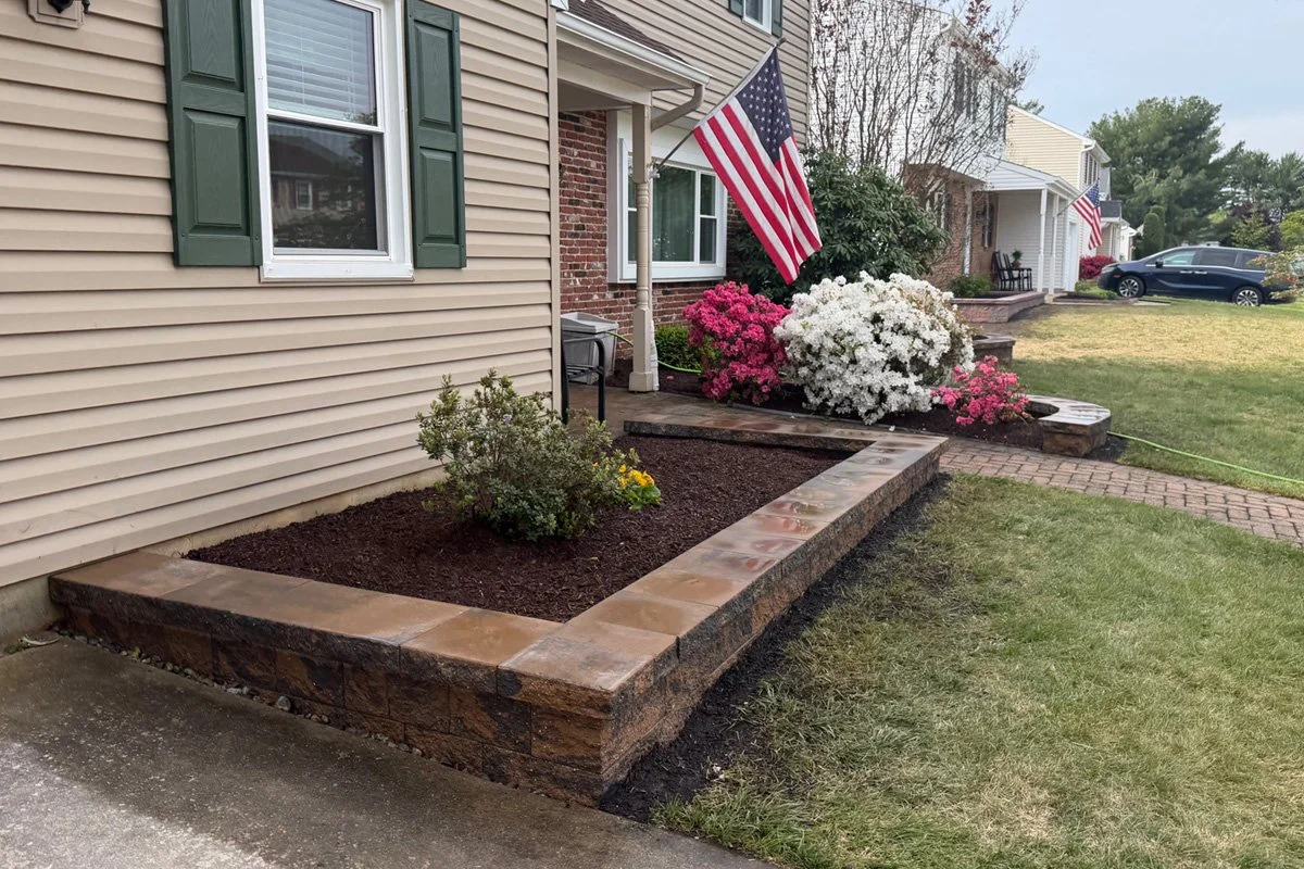 Raised driveway garden bed retaining wall constructed with Cambridge Matrix Toffee Onyx wall blocks in Sewell, NJ.