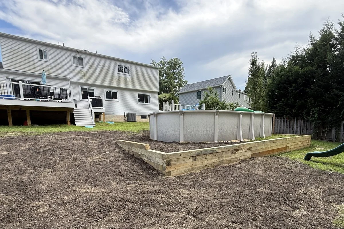 A custom 6x6 timber retaining wall engineered and installed by JPL Landscaping to level a sloped backyard around an above-ground swimming pool in Washington Township, NJ.