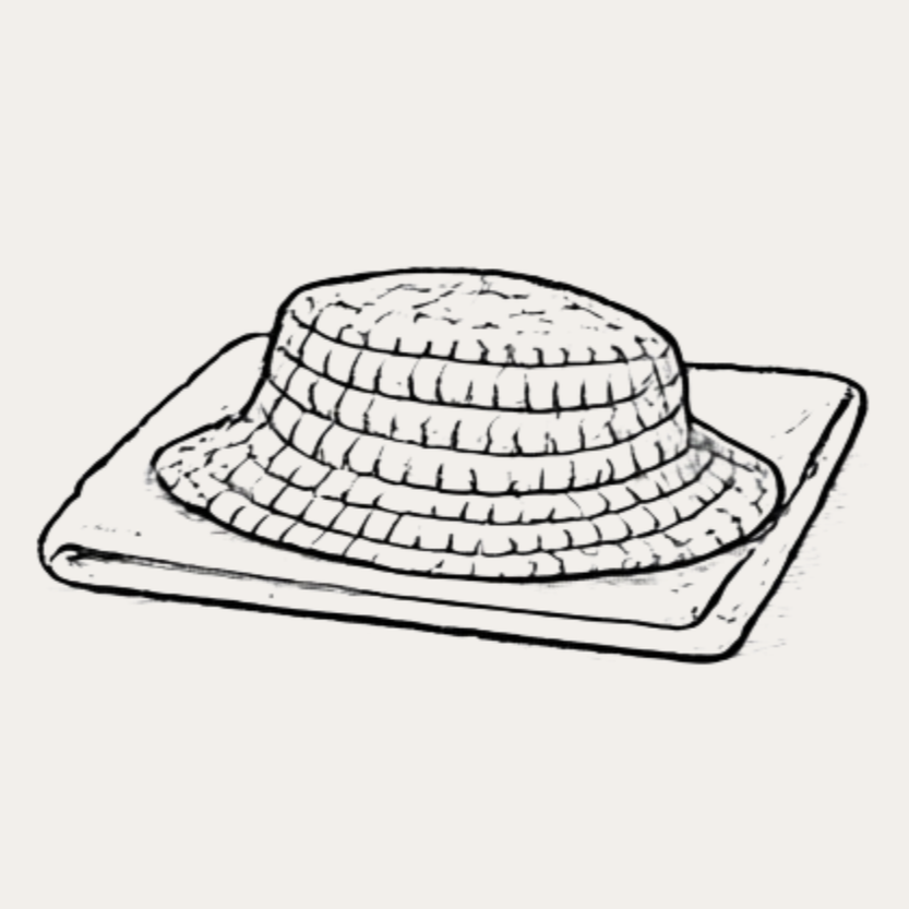 A black and white illustration of a straw hat on a folded cloth or napkin.