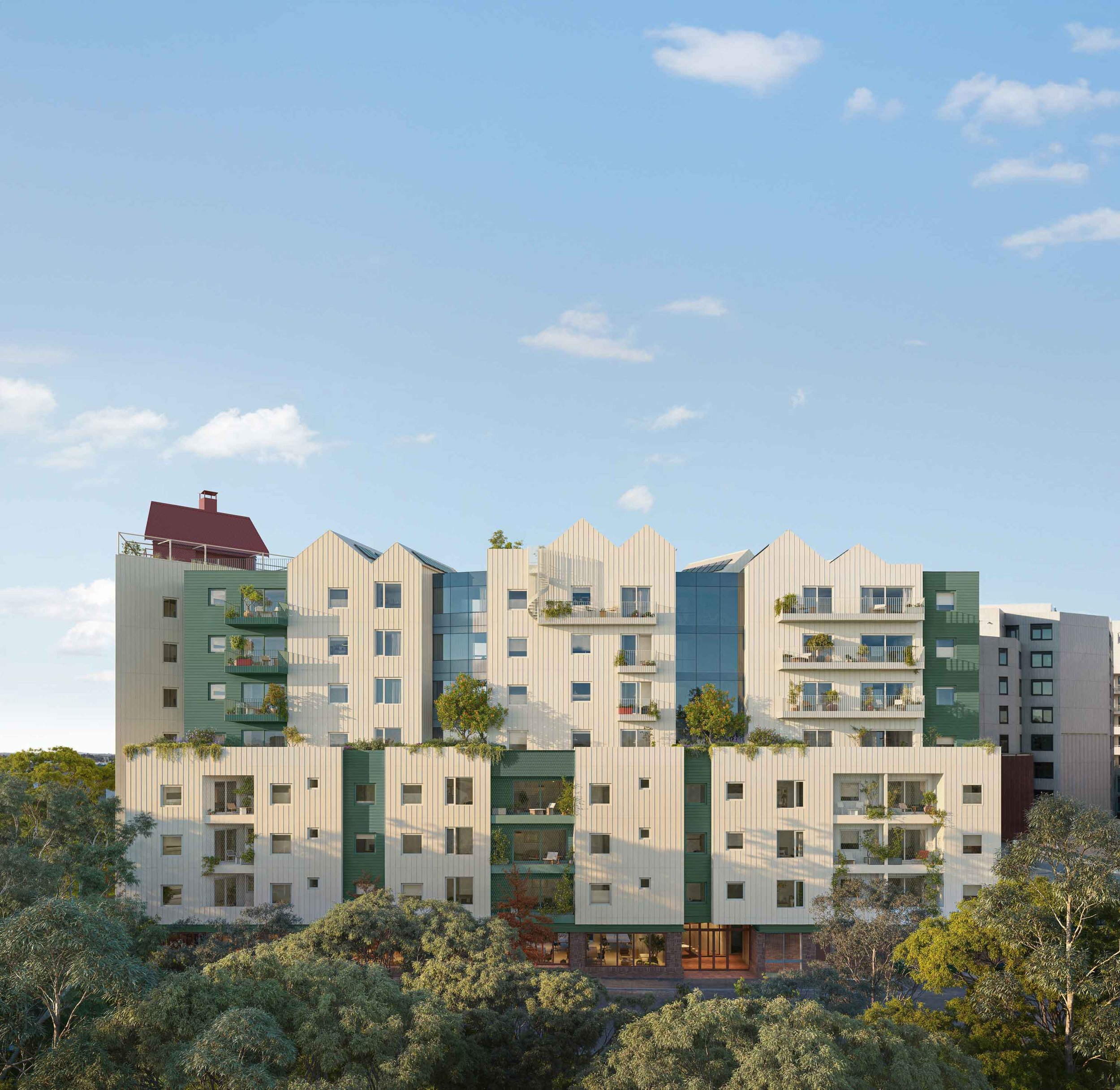 A modern multi-storey building with a colorful geometric facade, surrounded by lush trees under a bright blue sky with scattered clouds.