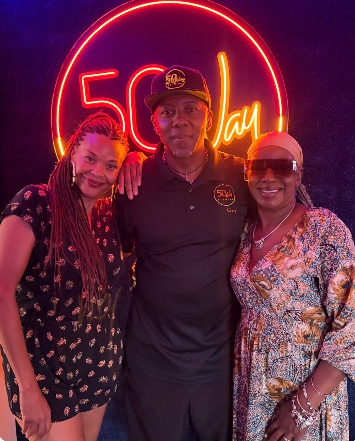 Erickka Jones, Craig Thompson and Carmaletha Griswold, standing together in front of the '50 Way Studios' sign after shooting The Brew Is Back podcast.