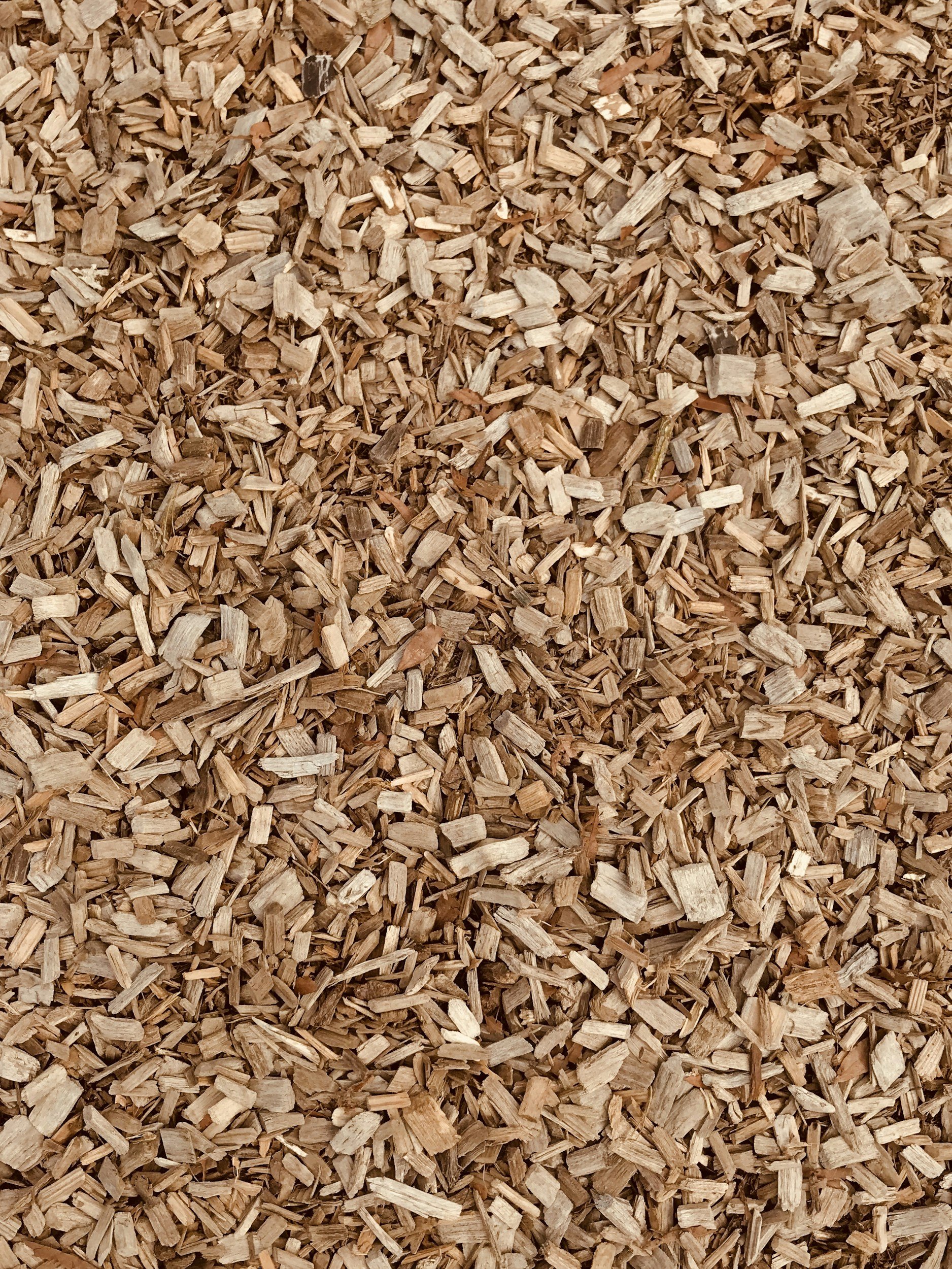A close-up image of wood chips or wood bark mulch.