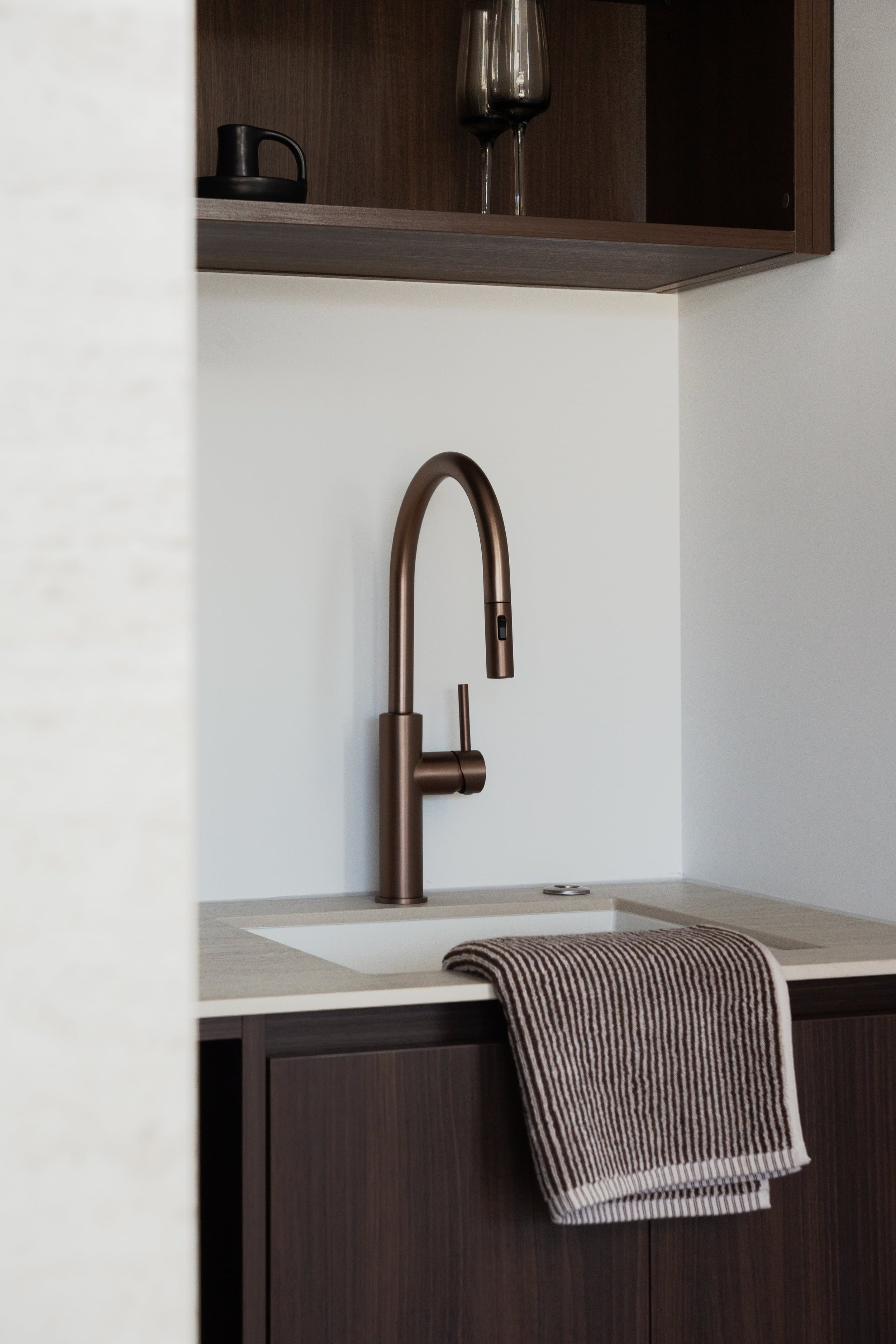 Image is of Antique Bronze Kitchen Mixer, Dark Timber Open Shelving, Stone Benchtop and White Granite Sink