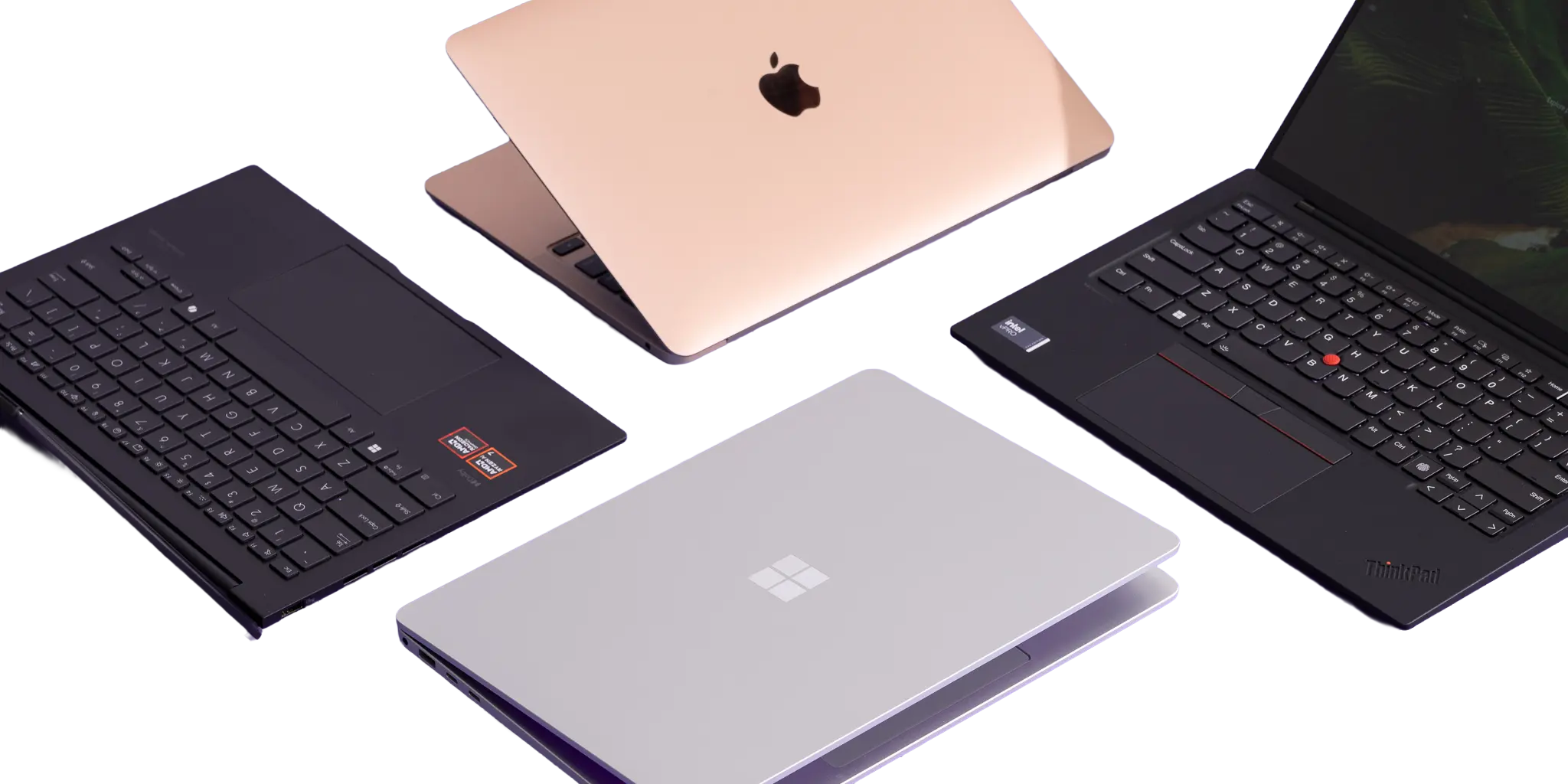Top view of several laptops of different brands and colors arranged on a purple background.