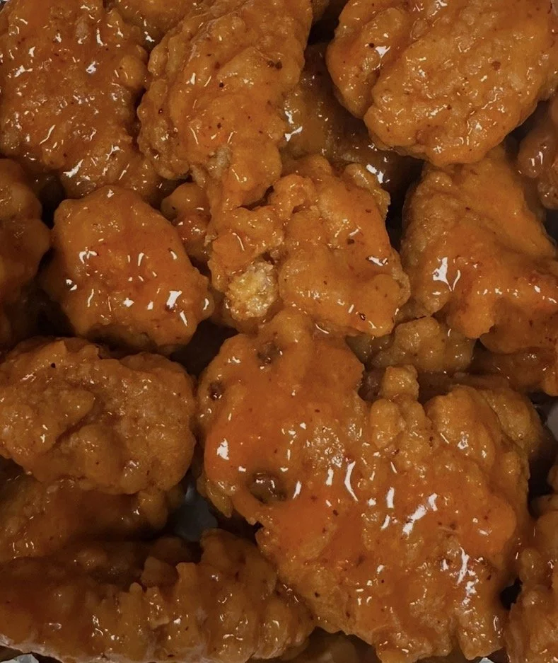 Close-up of multiple pieces of glazed fried chicken.
