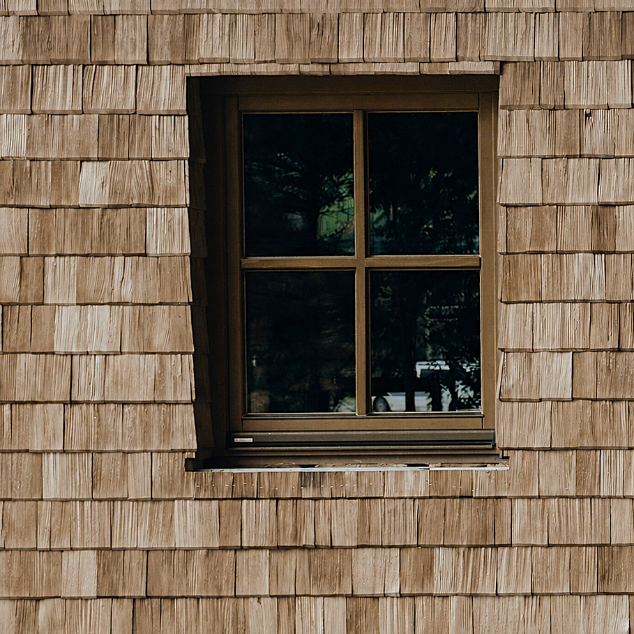 Holzfassade mit Schindeldeckung in Lärche. 
