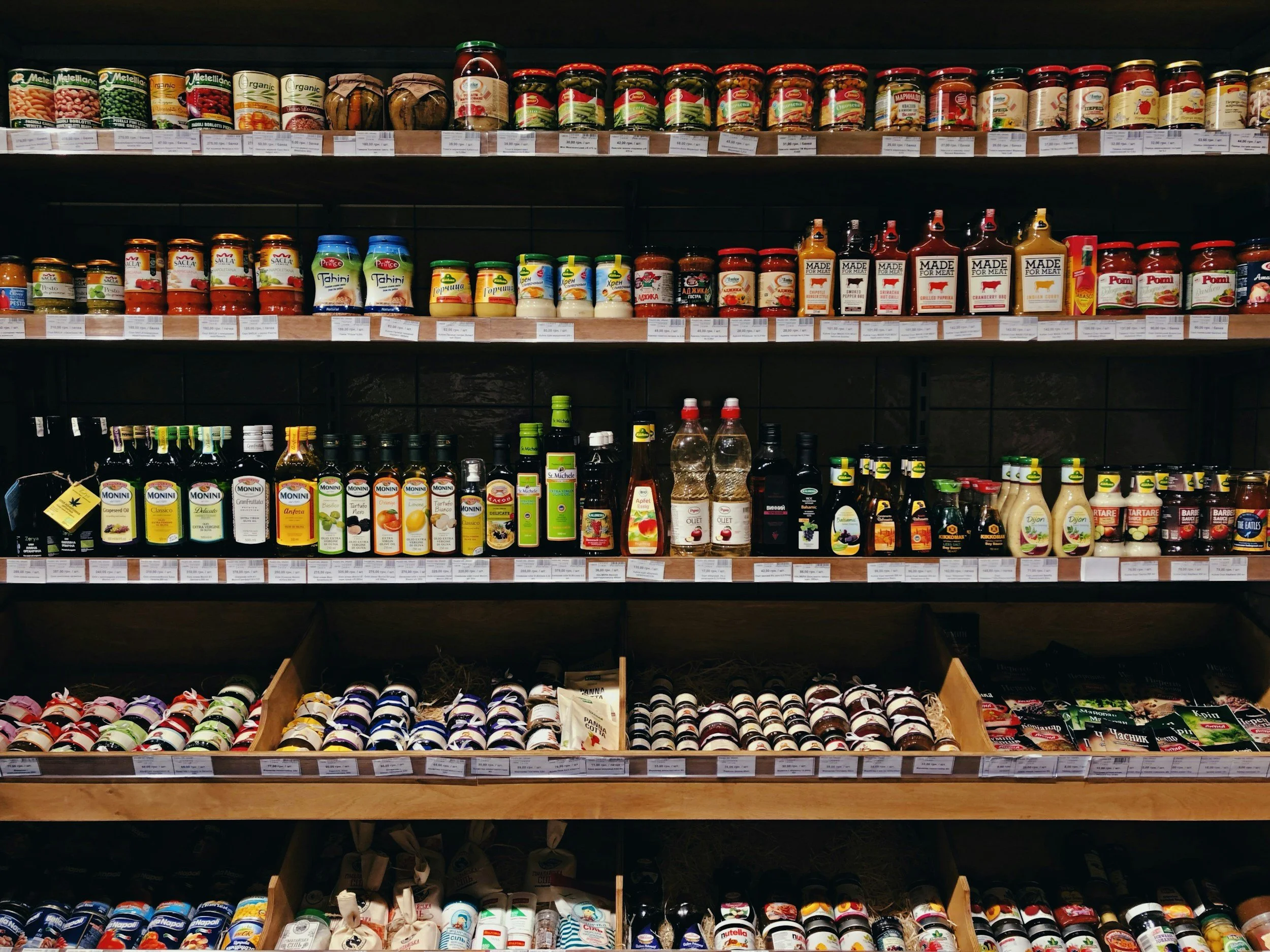 A supermarket shelf showing bottles and jars with sauces and condiments
