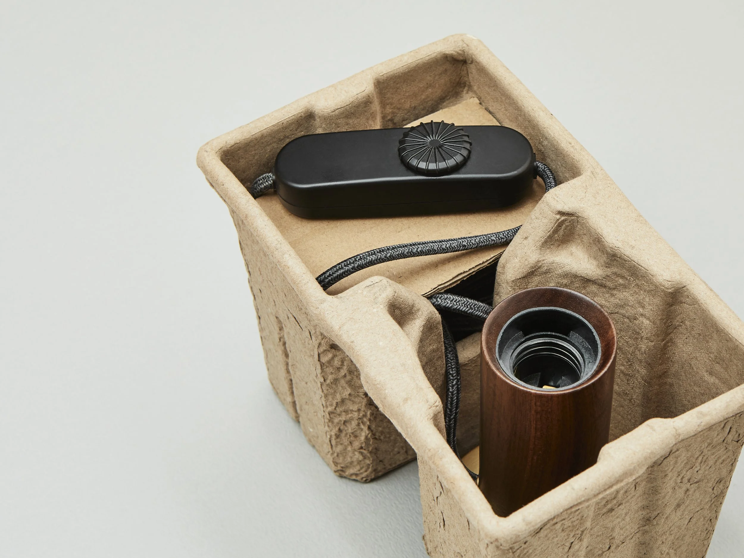 Close-up view of a Tala lamp crafted wooden base and integrated dimmer control switch.