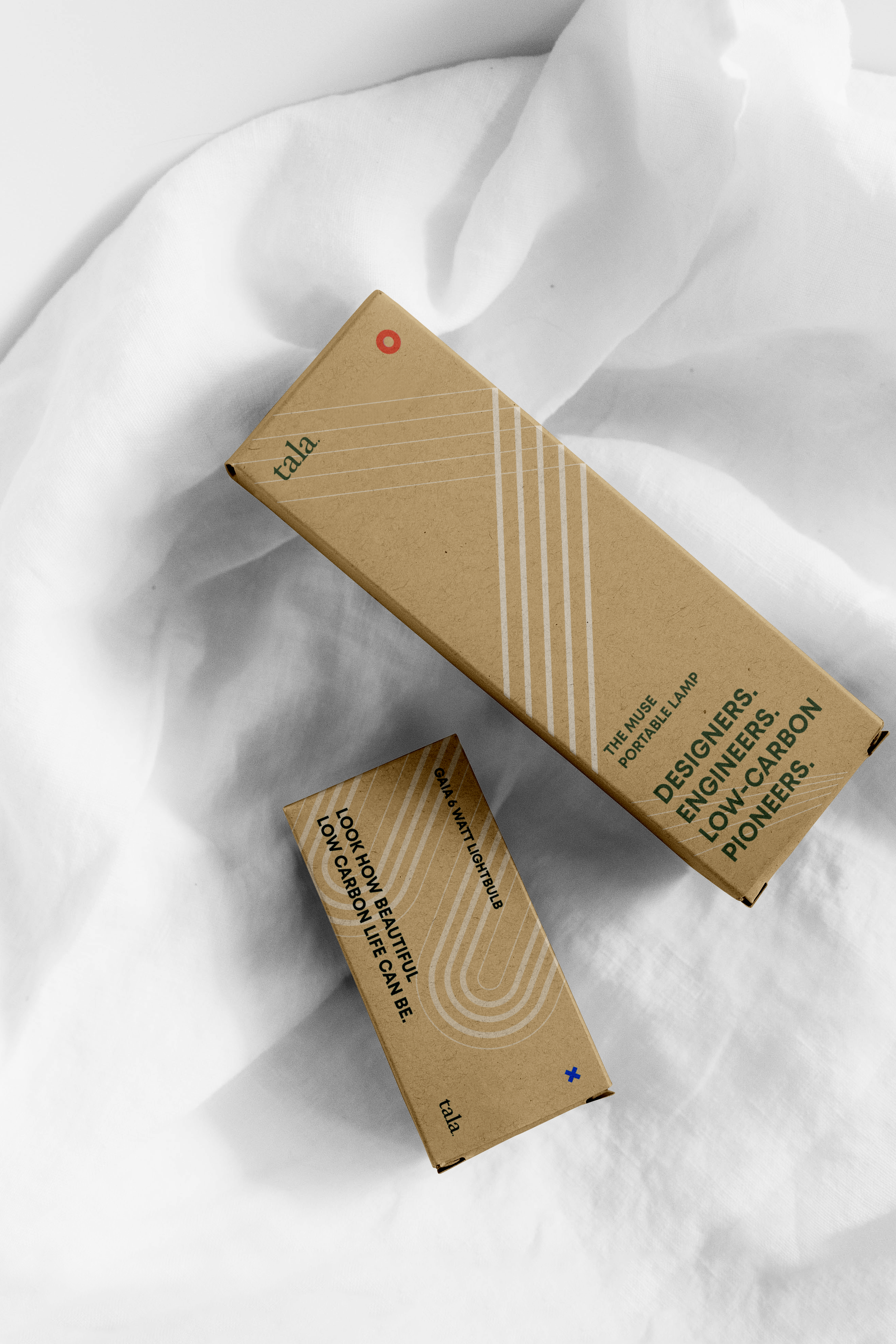 Two rectangular Tala branded packaging boxes featuring clean typography and dynamic line assets.