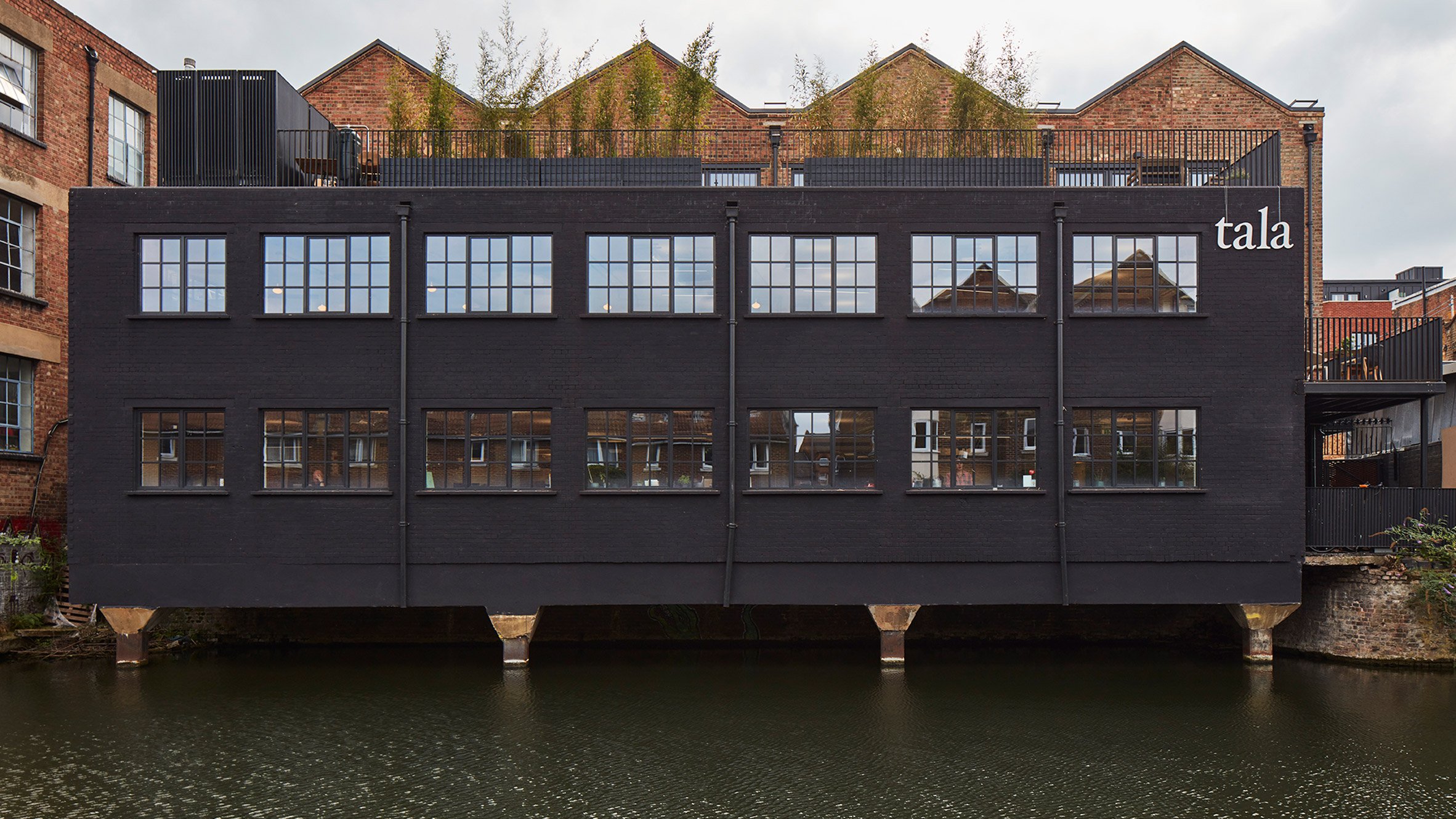 External view of the contemporary Tala studio office building overlooking a canal.