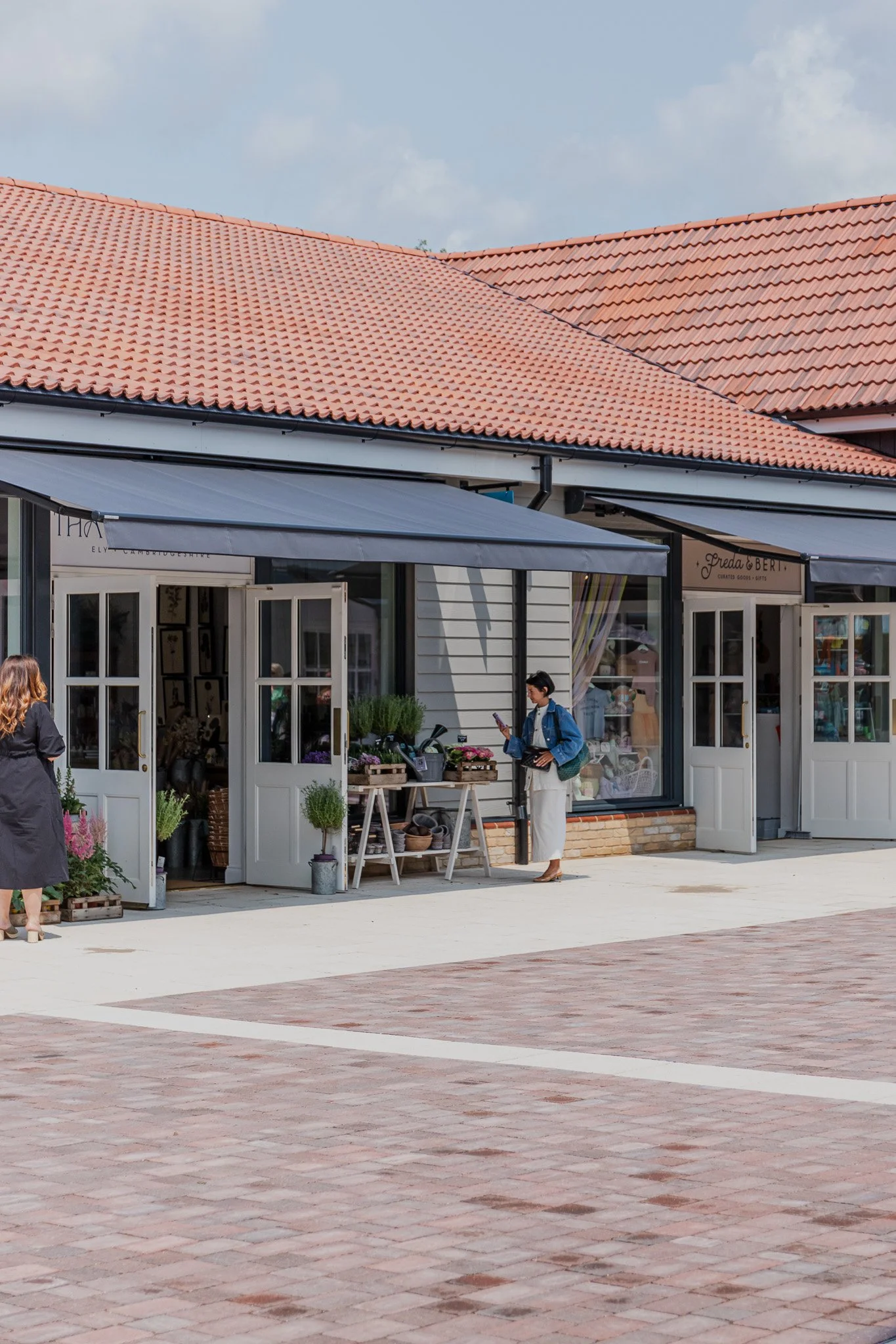 Courtyard view of Ben’s Yard retail village storefronts with visitors.