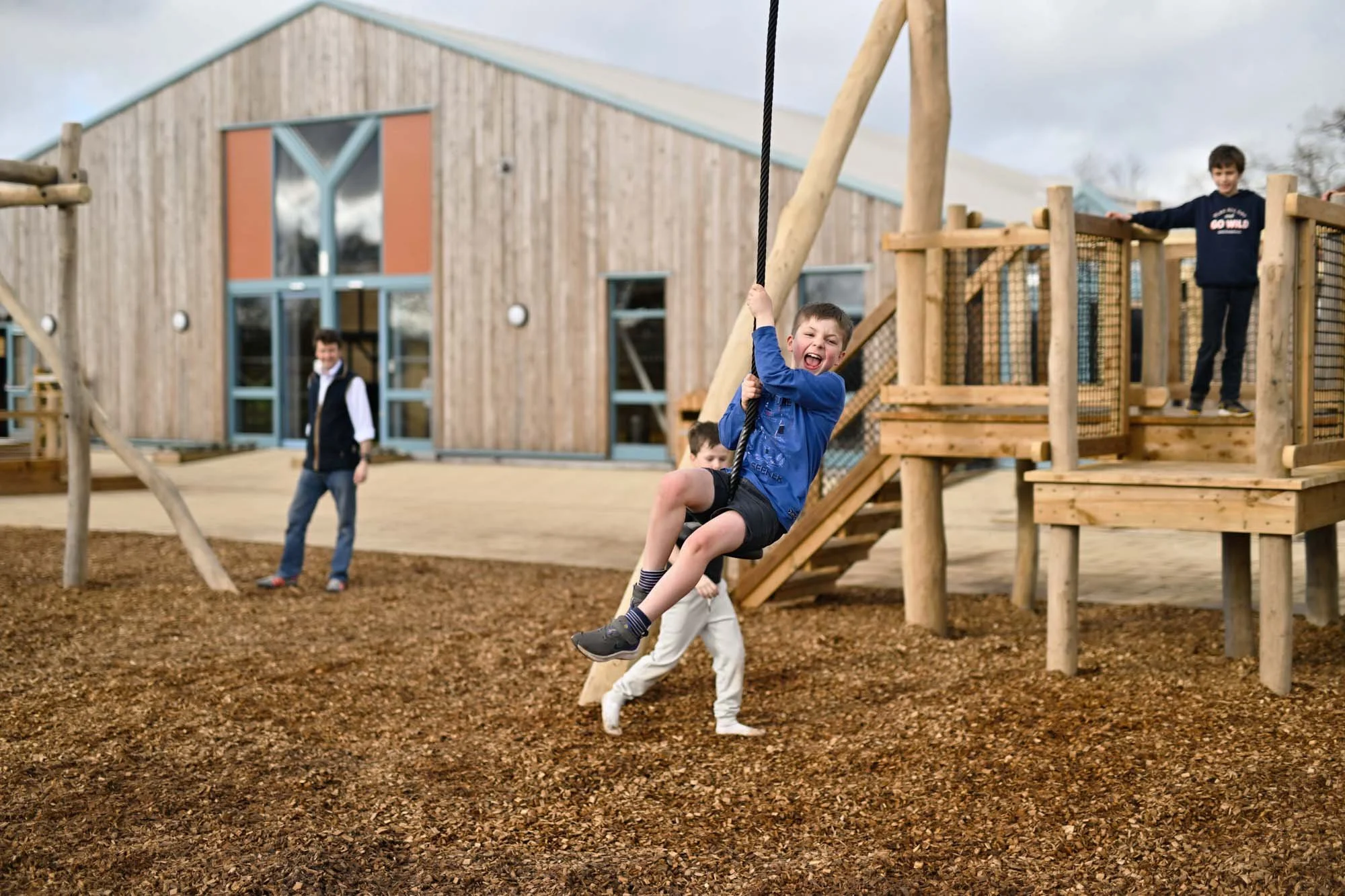 An energetic child riding the outdoor zip wire at the Hockerhill Adventure Playbarn outdoor paddock.