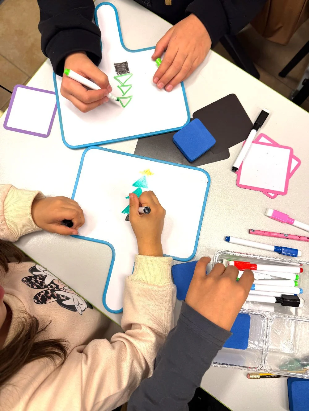 Children working together on a colourful activity during a playful learning session at Hello Bridge Academy.