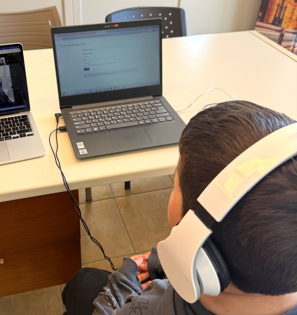 Student wearing headphones while taking part in an online learning activity at Hello Bridge Academy.