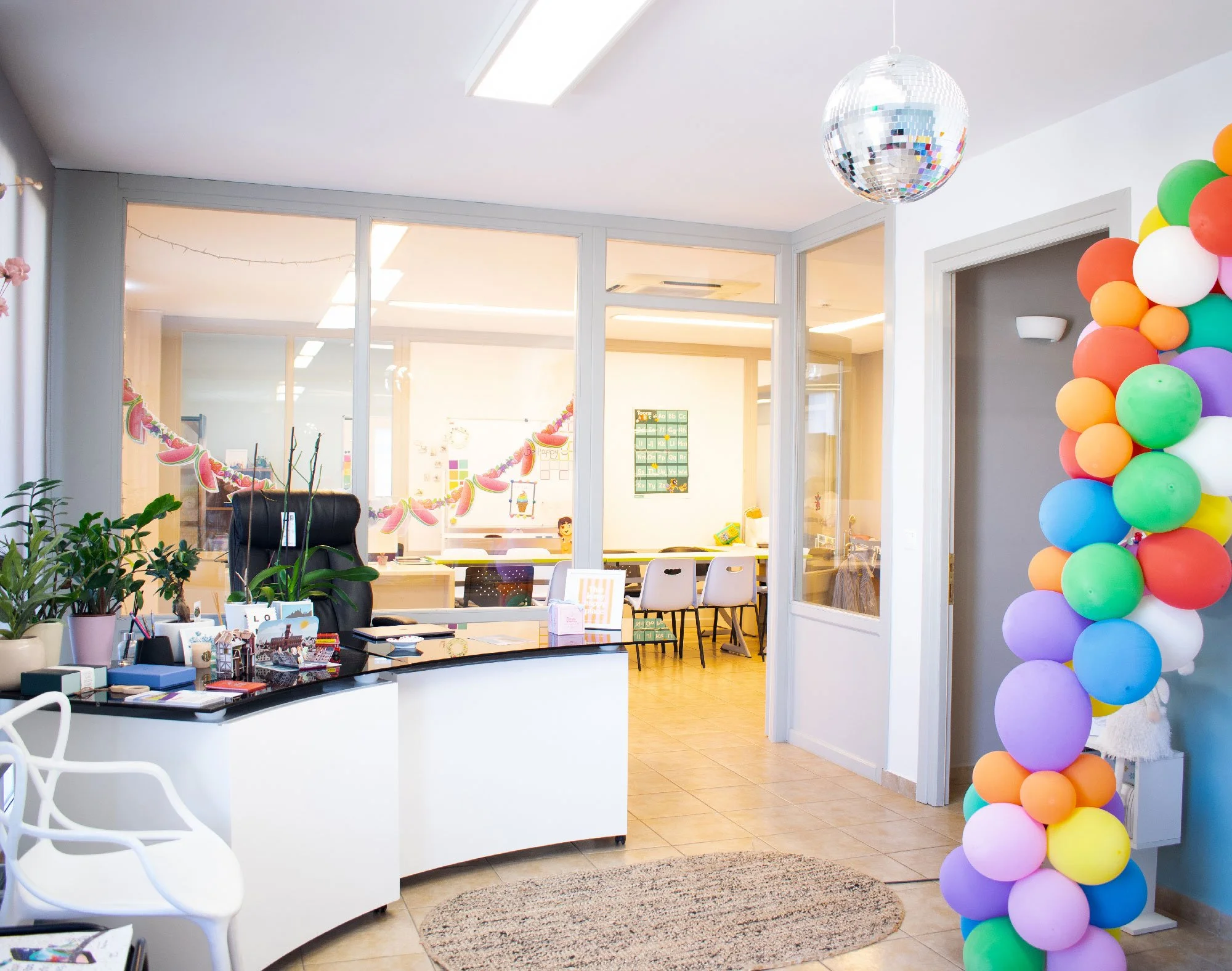 Entrance and reception area of Hello Bridge Academy in Syros with colourful balloons and view into the classrooms.