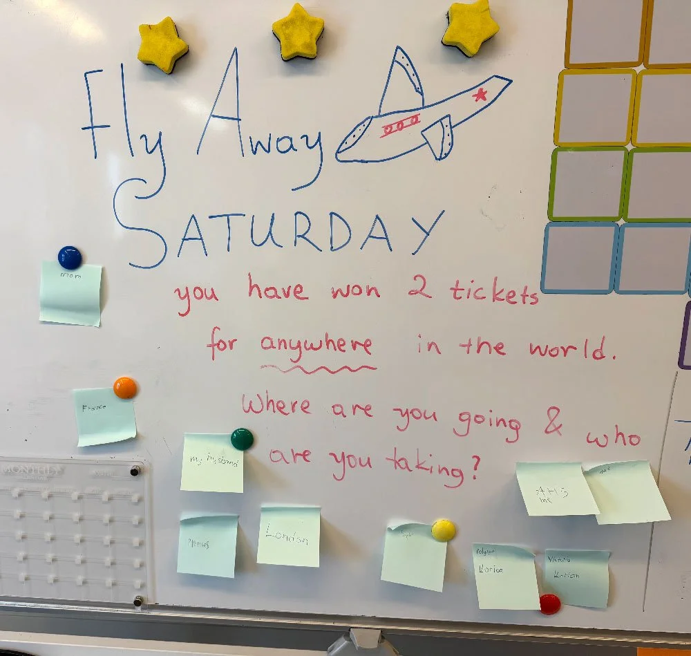Whiteboard activity at Hello Bridge Academy with a travel-themed English prompt encouraging students to practise communication and imagination.