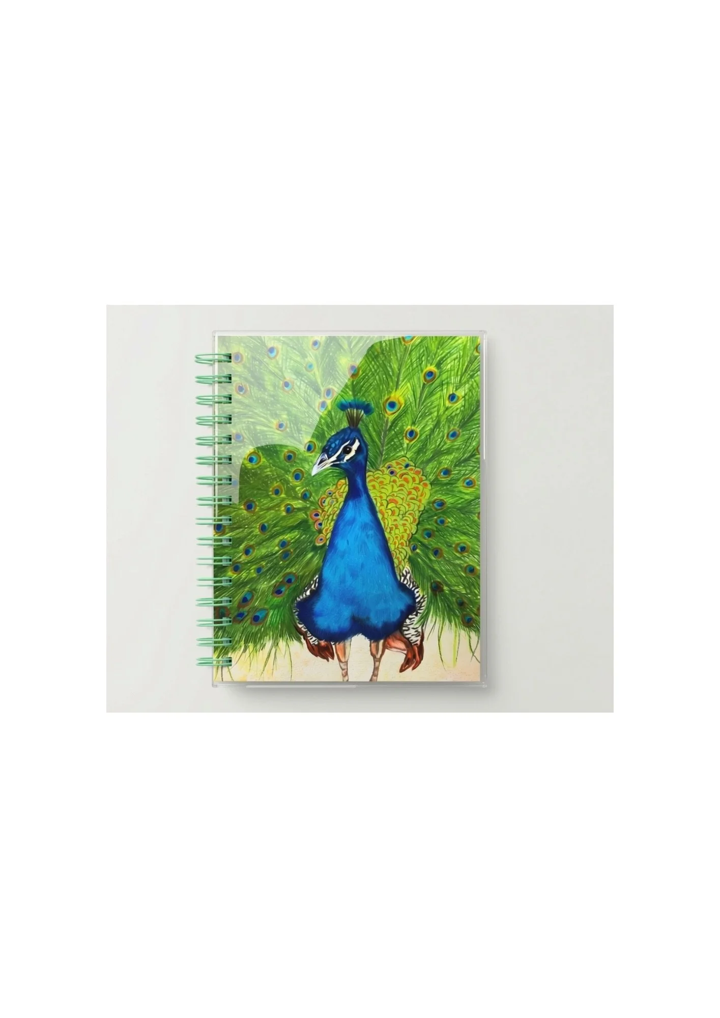 Colorful notebook with a peacock illustration on the cover, placed on a white surface.