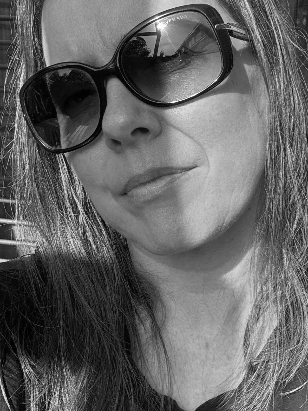 Close-up black-and-white photo of artist Michele, wearing large sunglasses, and her face partially out of frame.