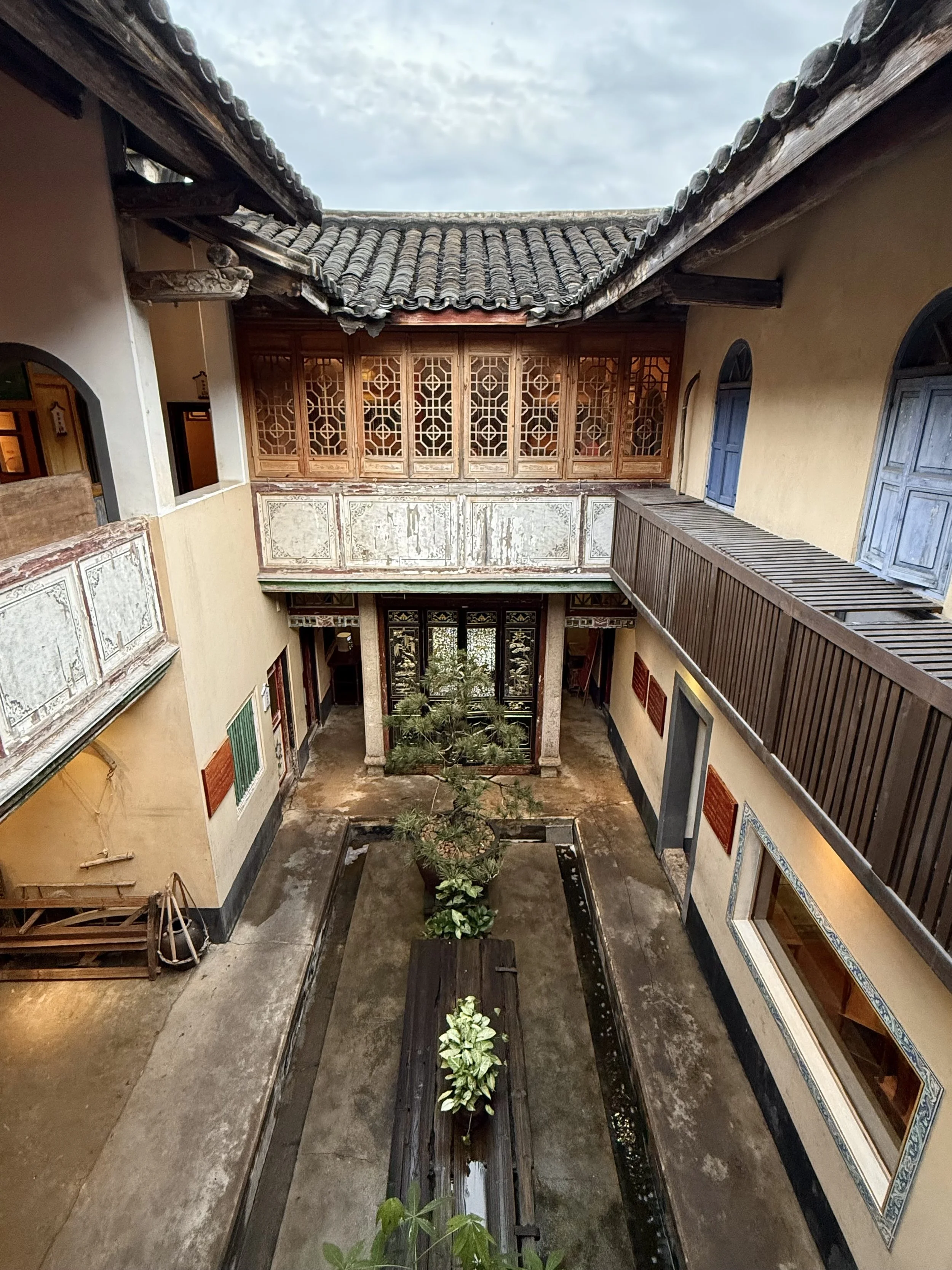 Interior of Chengde Lou showing stone columns, carved timber screens and decorated architectural panels.