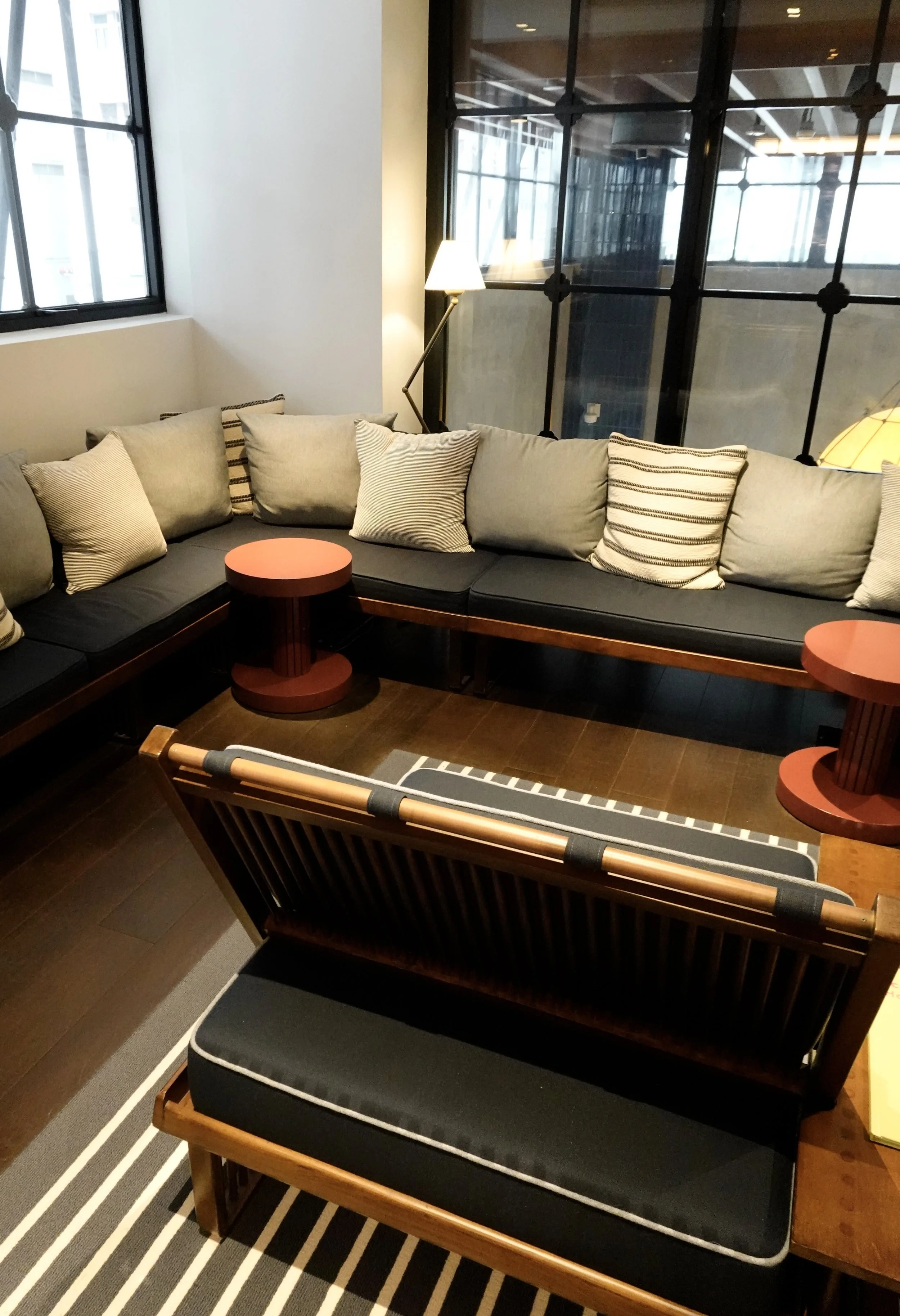 Reception lounge at The Fleming with timber seating and small red circular tables