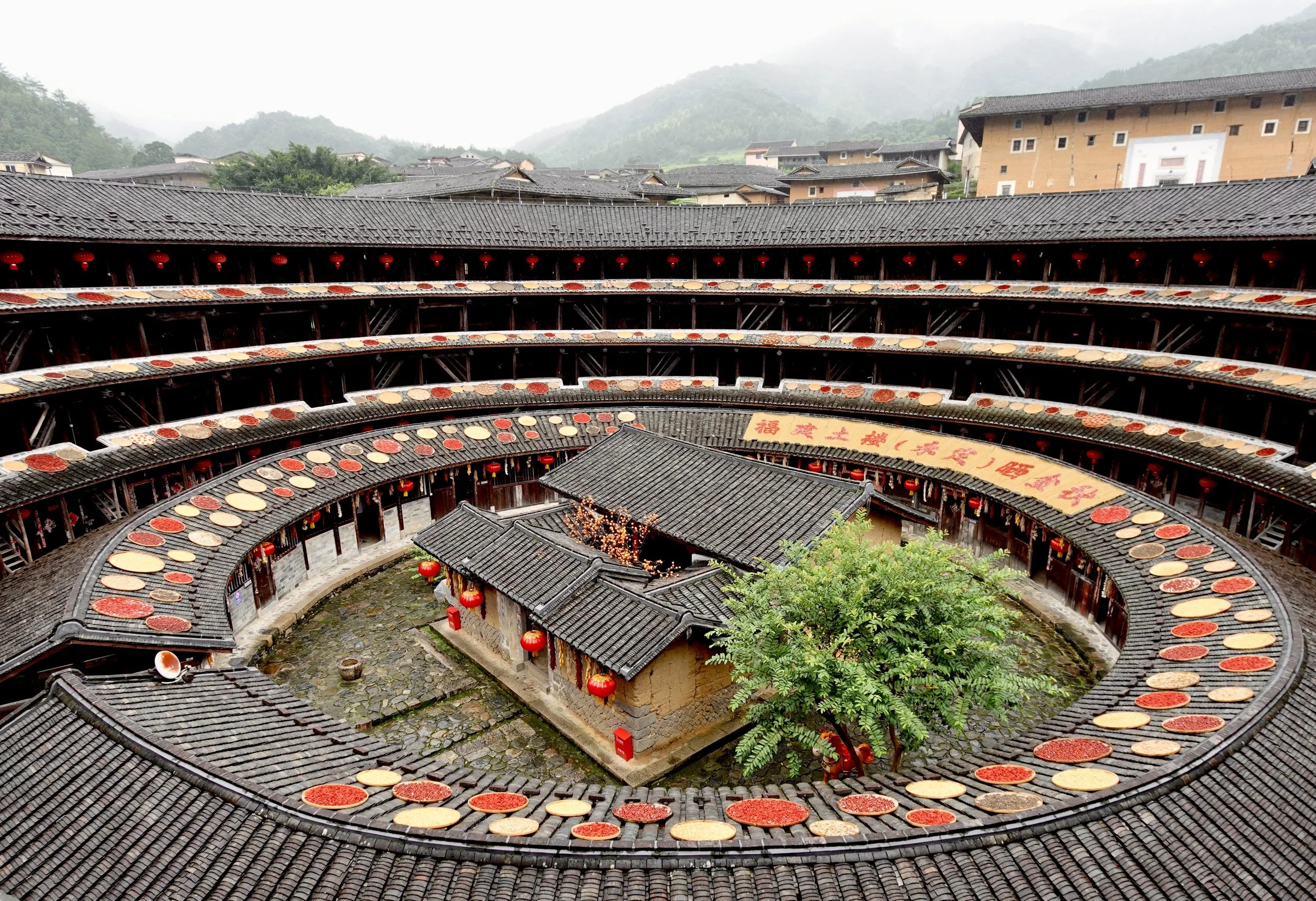 Interior courtyard of Jiqing Lou showing four levels of circular timber galleries surrounding an open central space.
