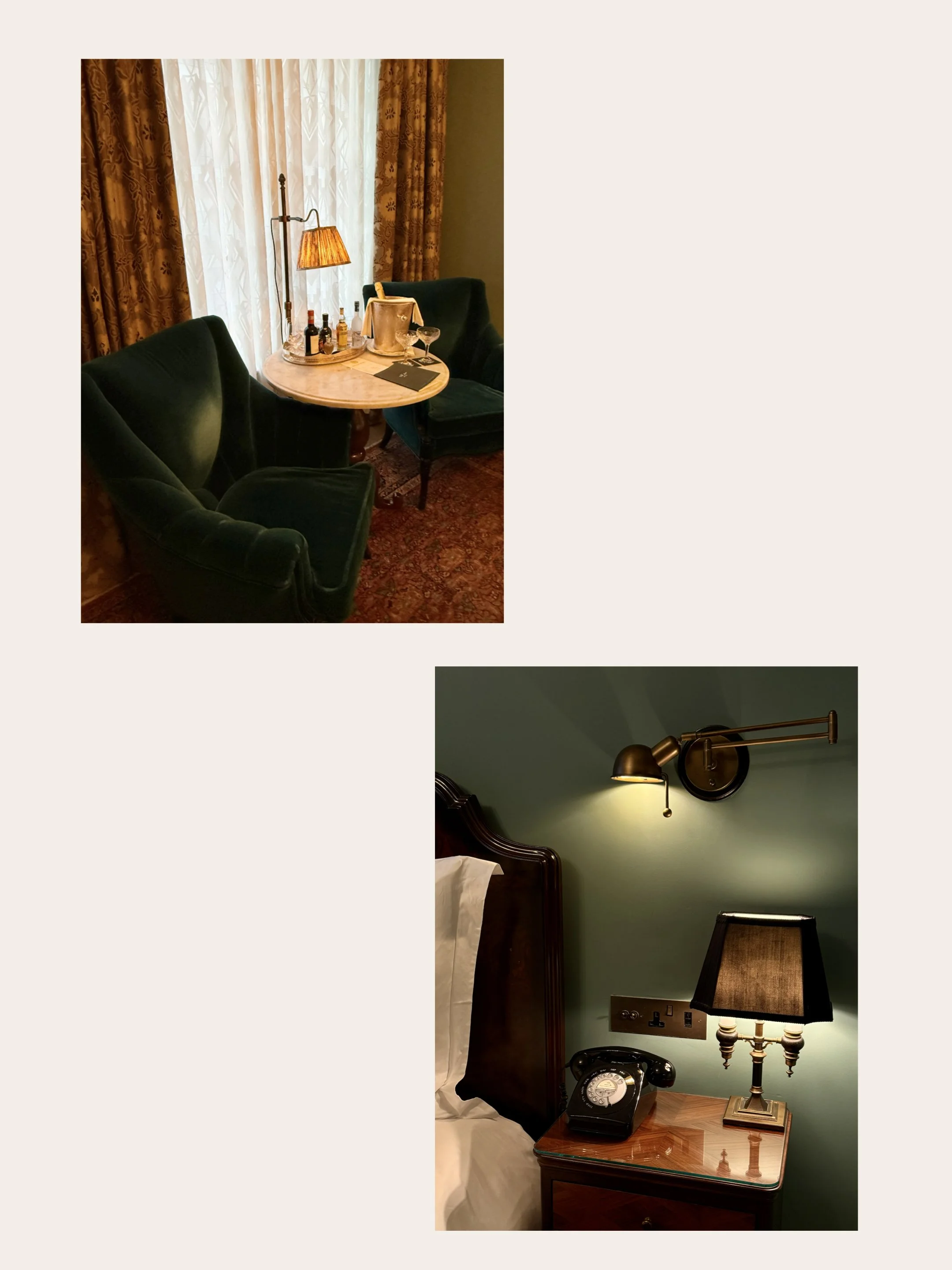 Two deep teal armchairs beside a round pale table holding a champagne bucket, glasses and minibar bottles, framed by patterned curtains and a shaded floor lamp.
