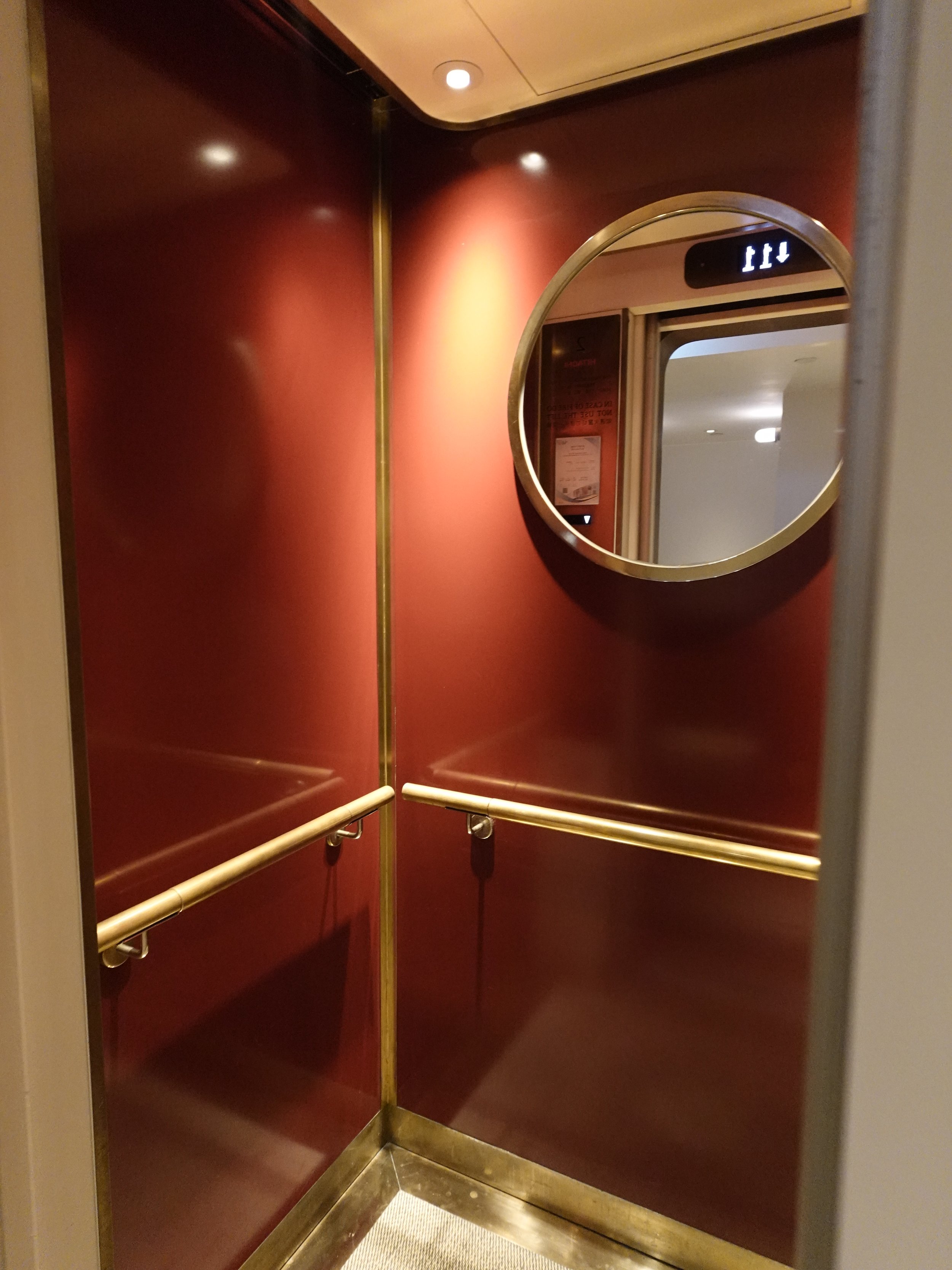 Deep red and brass elevator interior at The Fleming Hong Kong