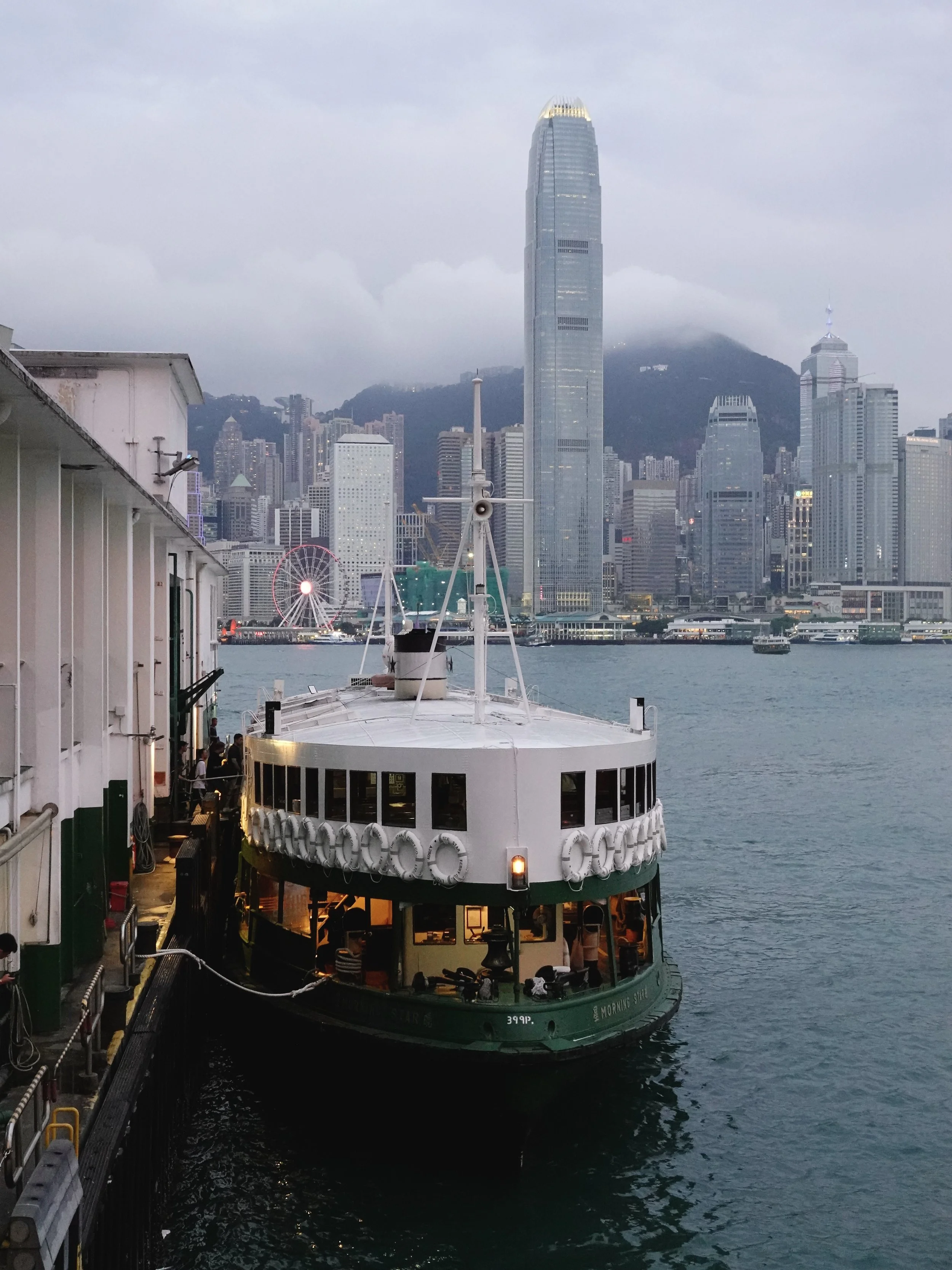Star Ferry at a pier on Victoria Harbour with the Hong Kong Island skyline behind