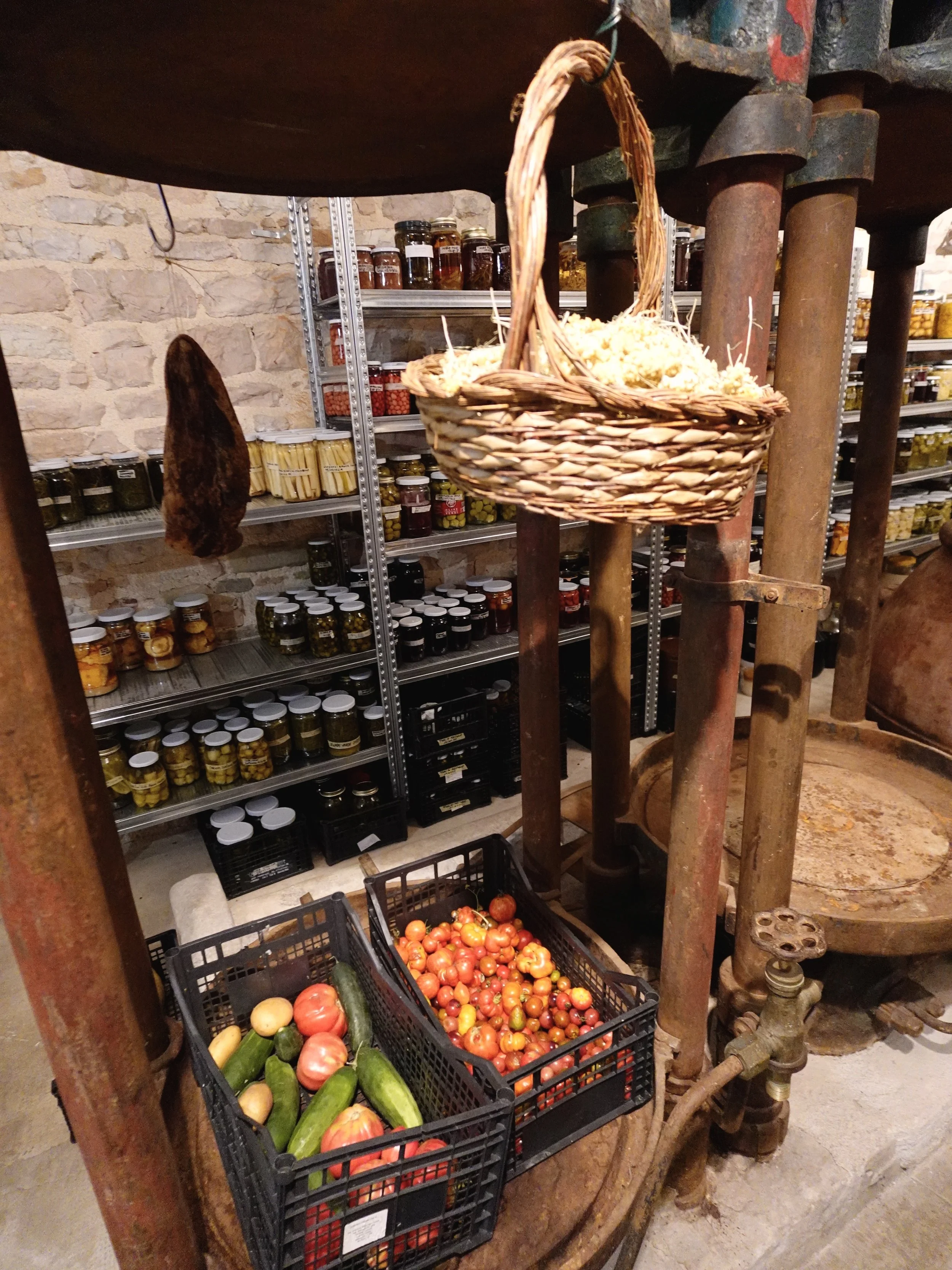 Old mill machinery, fresh vegetables and shelves of preserves in UNE’s working pantry.