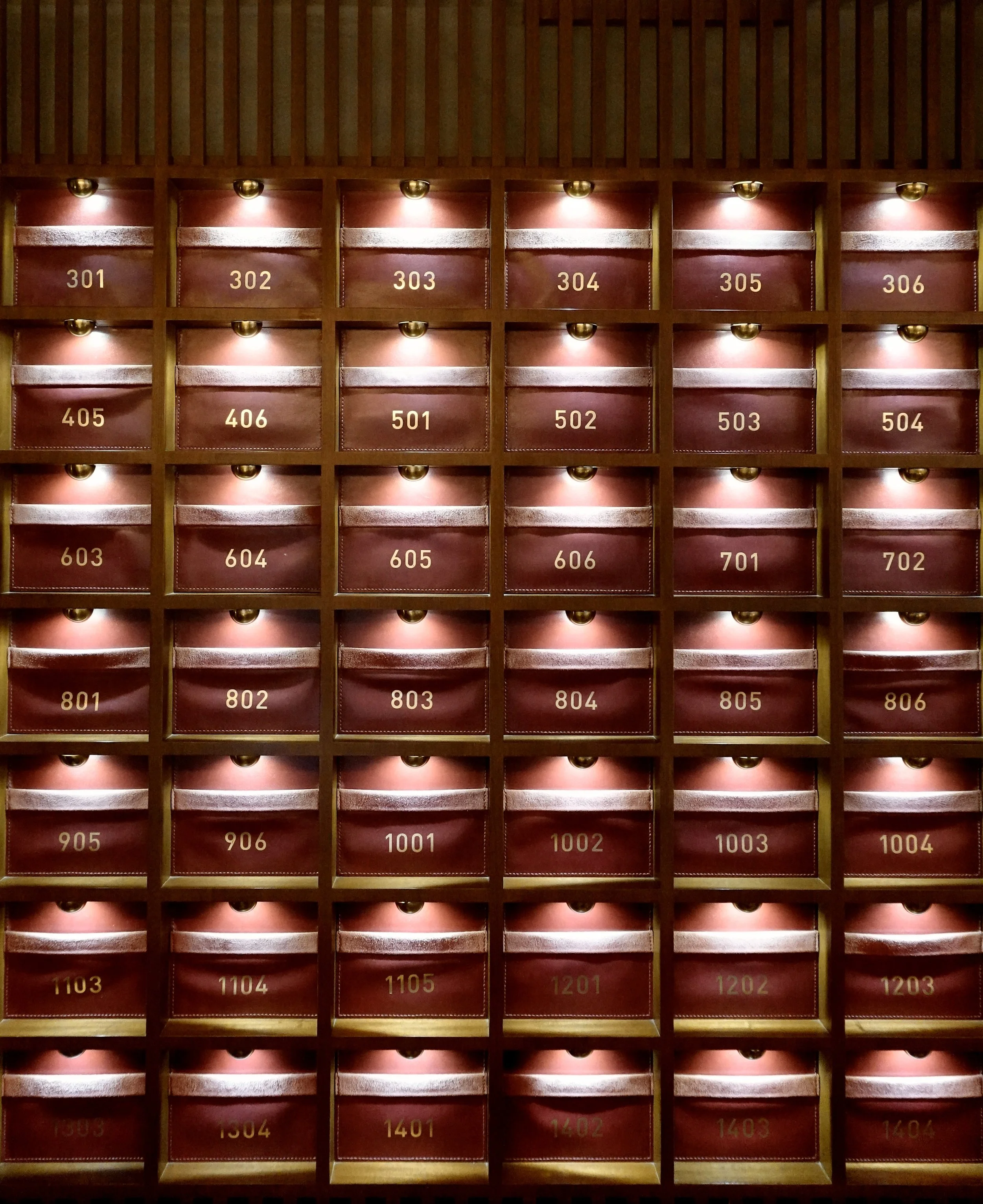 Wall of red and brass numbered compartments at The Fleming Hong Kong