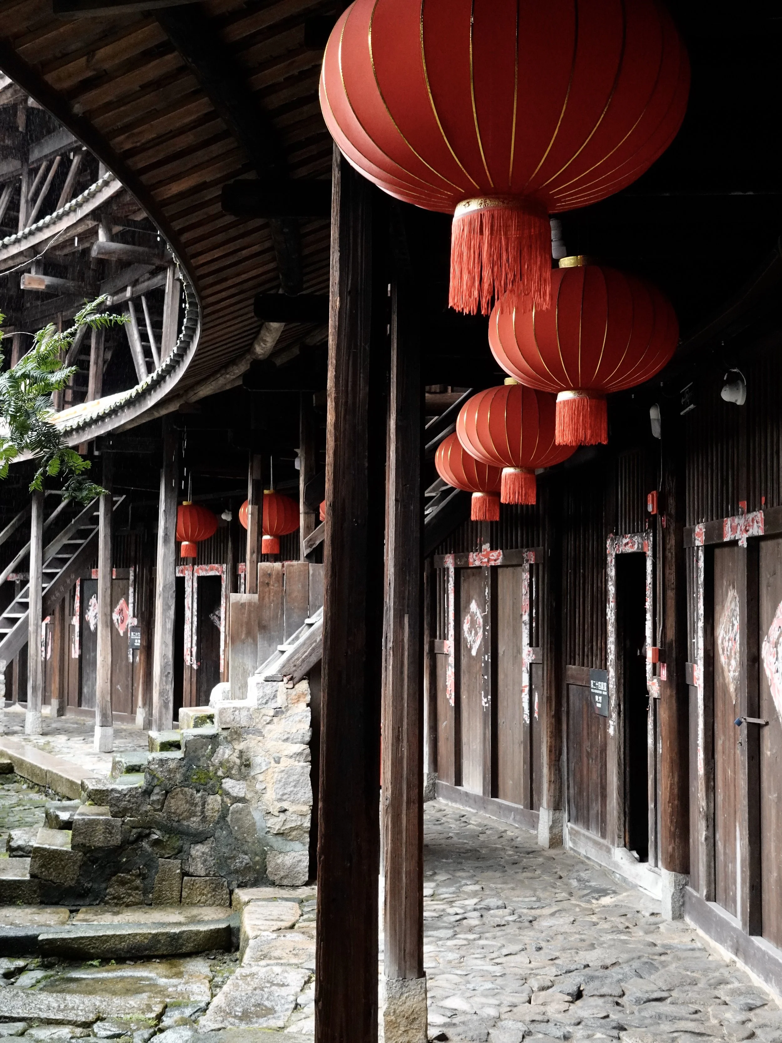 Timber staircases and open galleries rising through several floors inside the circular Jiqing Lou tulou.