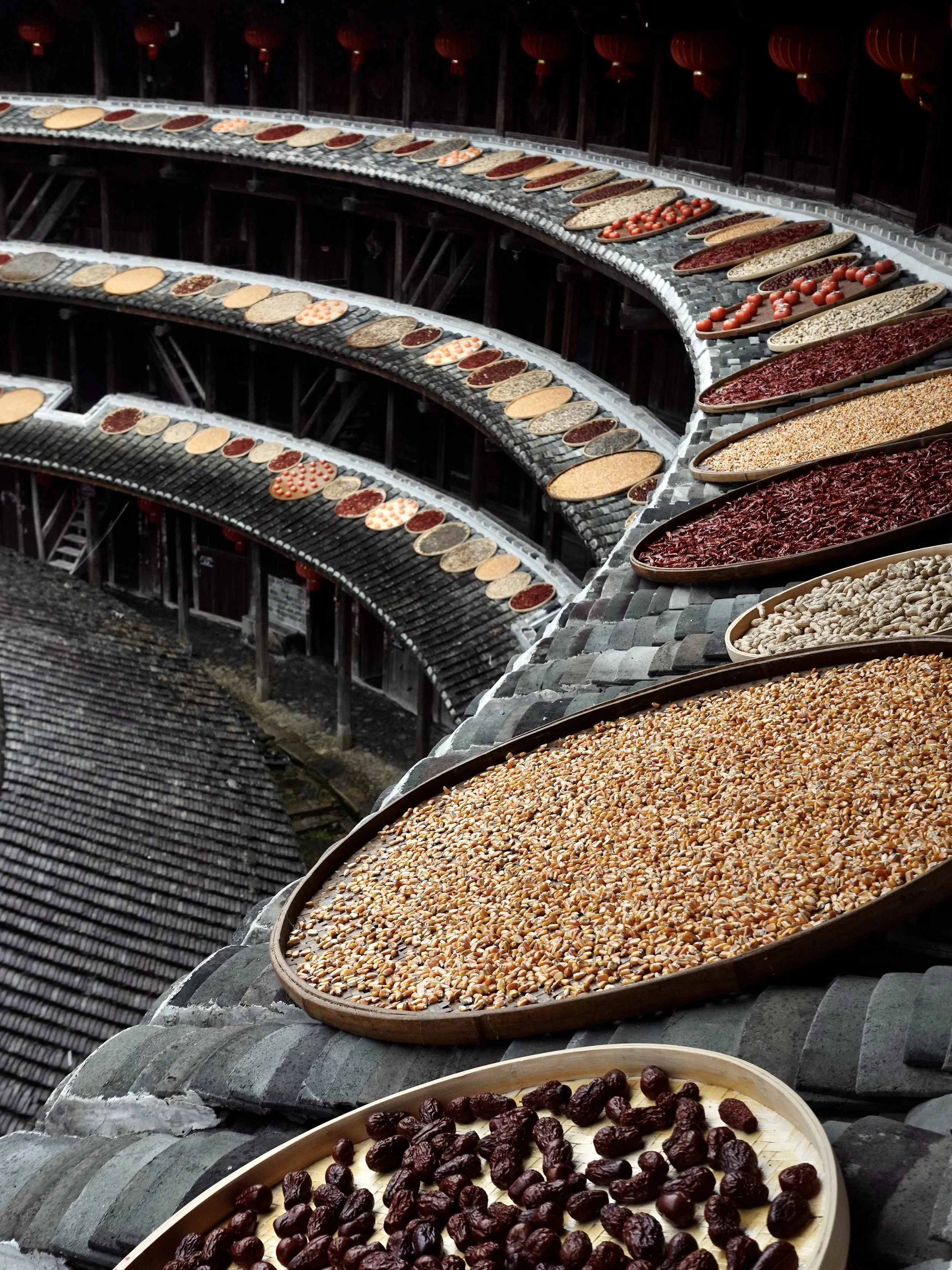Maize, peanuts and other produce laid out to dry on the stone paving inside Jiqing Lou.