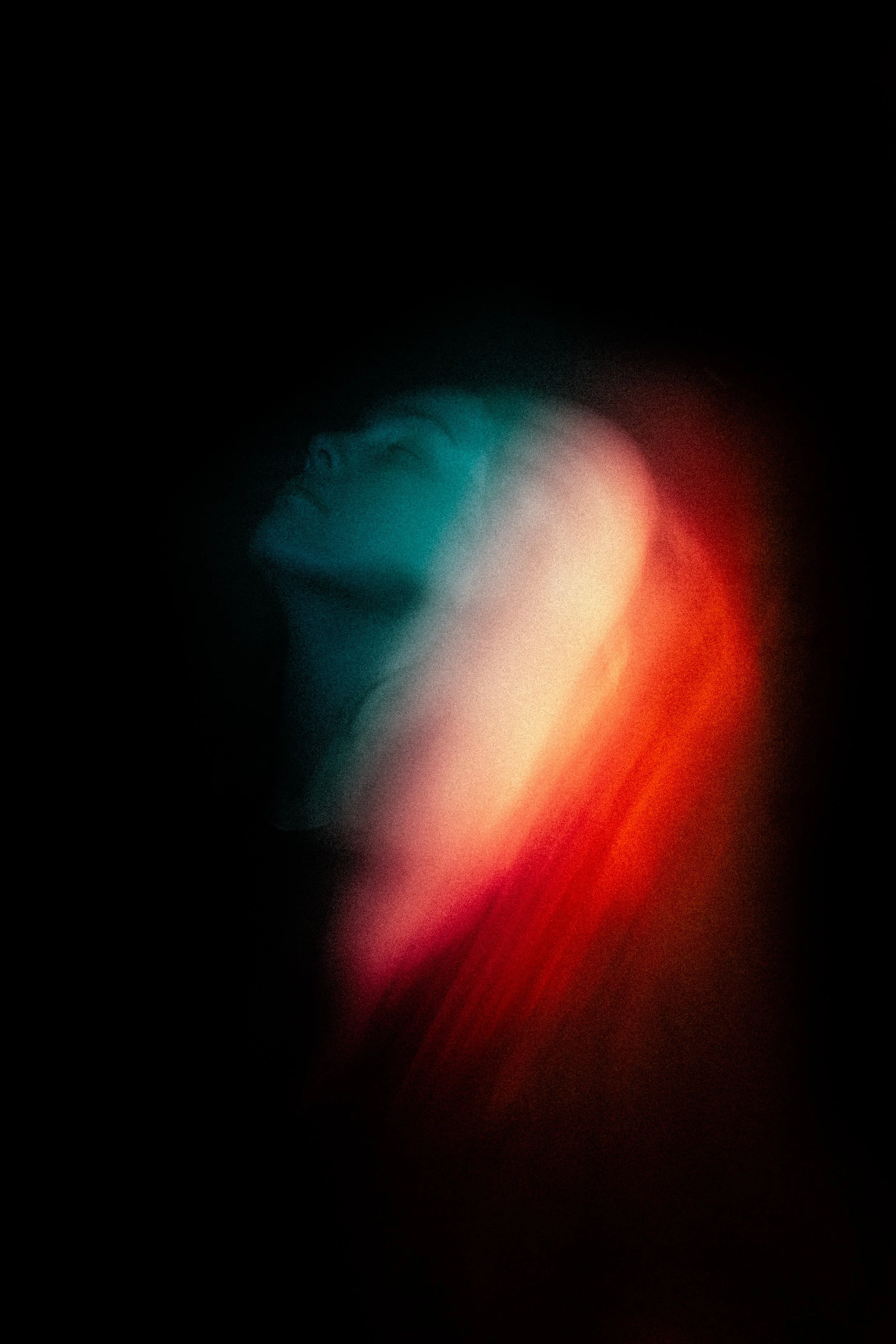 Abstract image with blurry multicolored light streaks in blue, white, red, and orange on a black background.