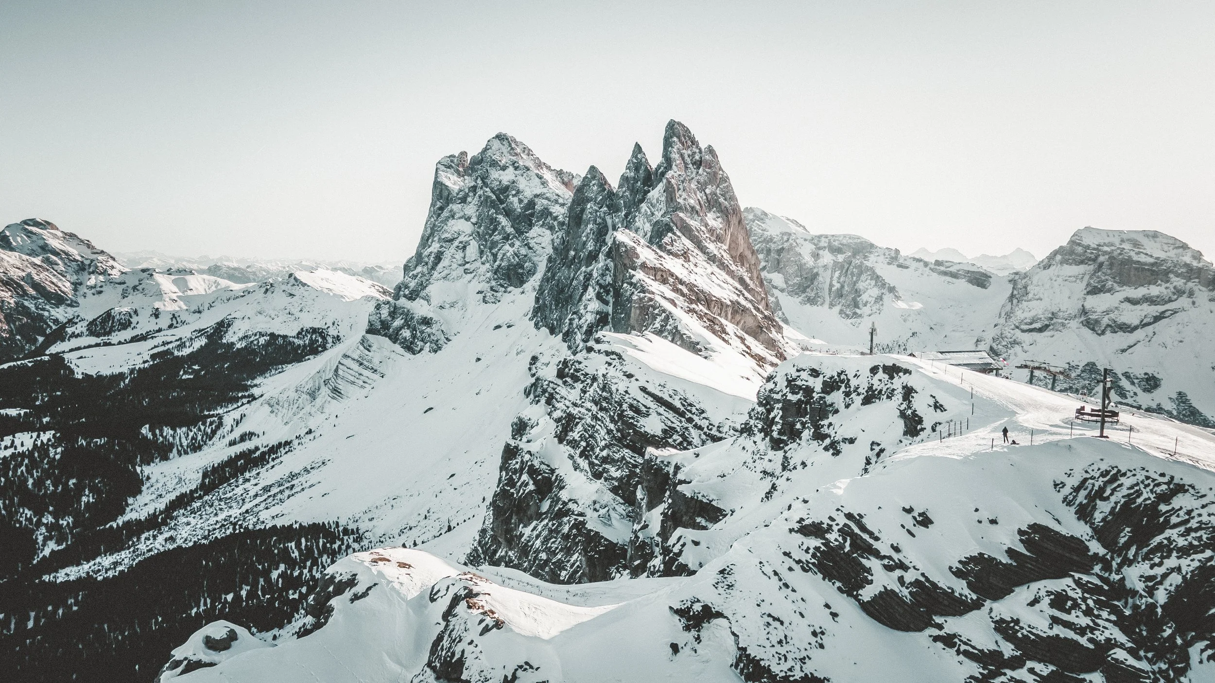 Snow-covered mountain peaks with ski lifts and a ski resort in the foreground.