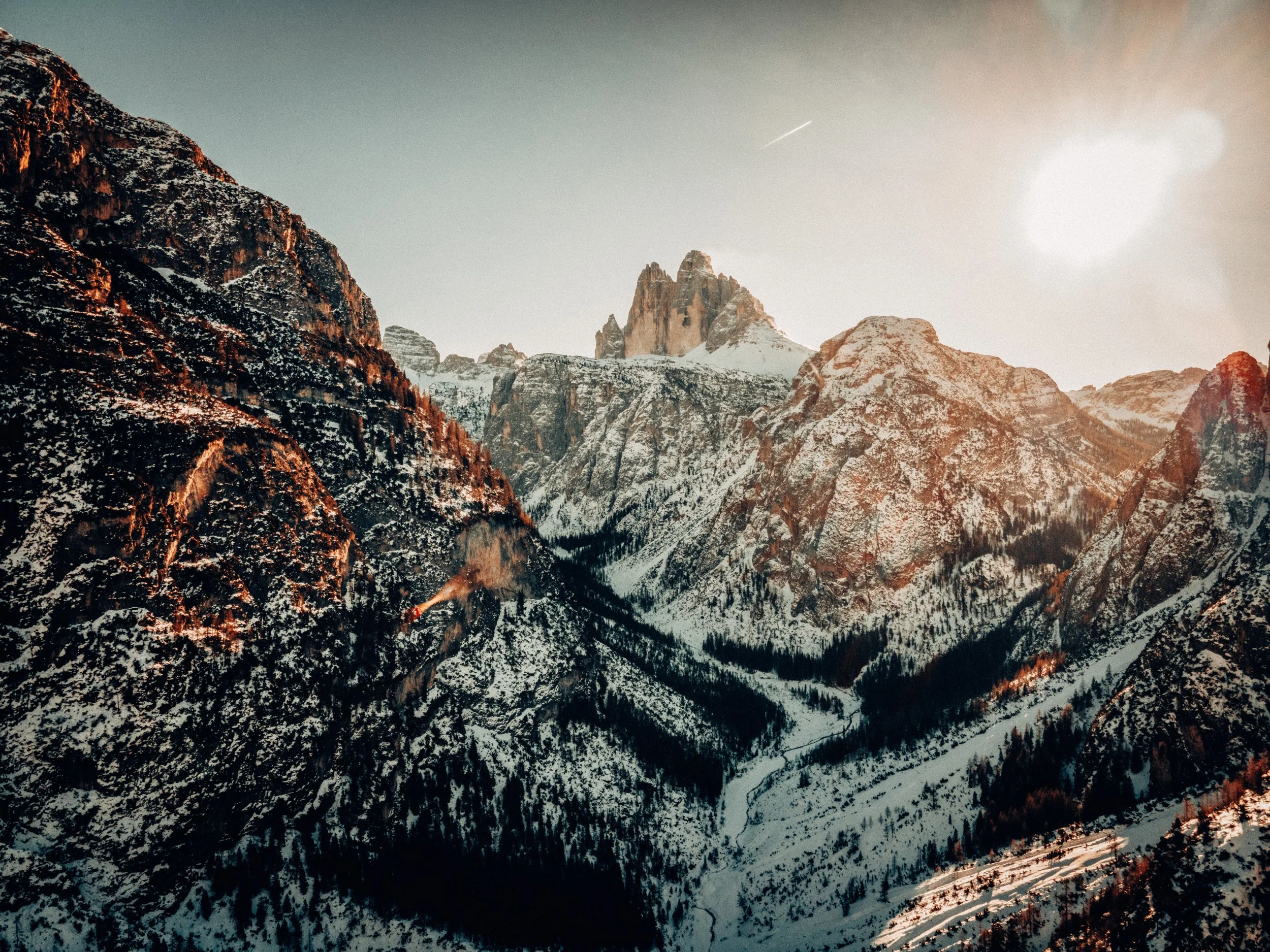 Snow-capped mountains at sunrise or sunset with a clear sky.