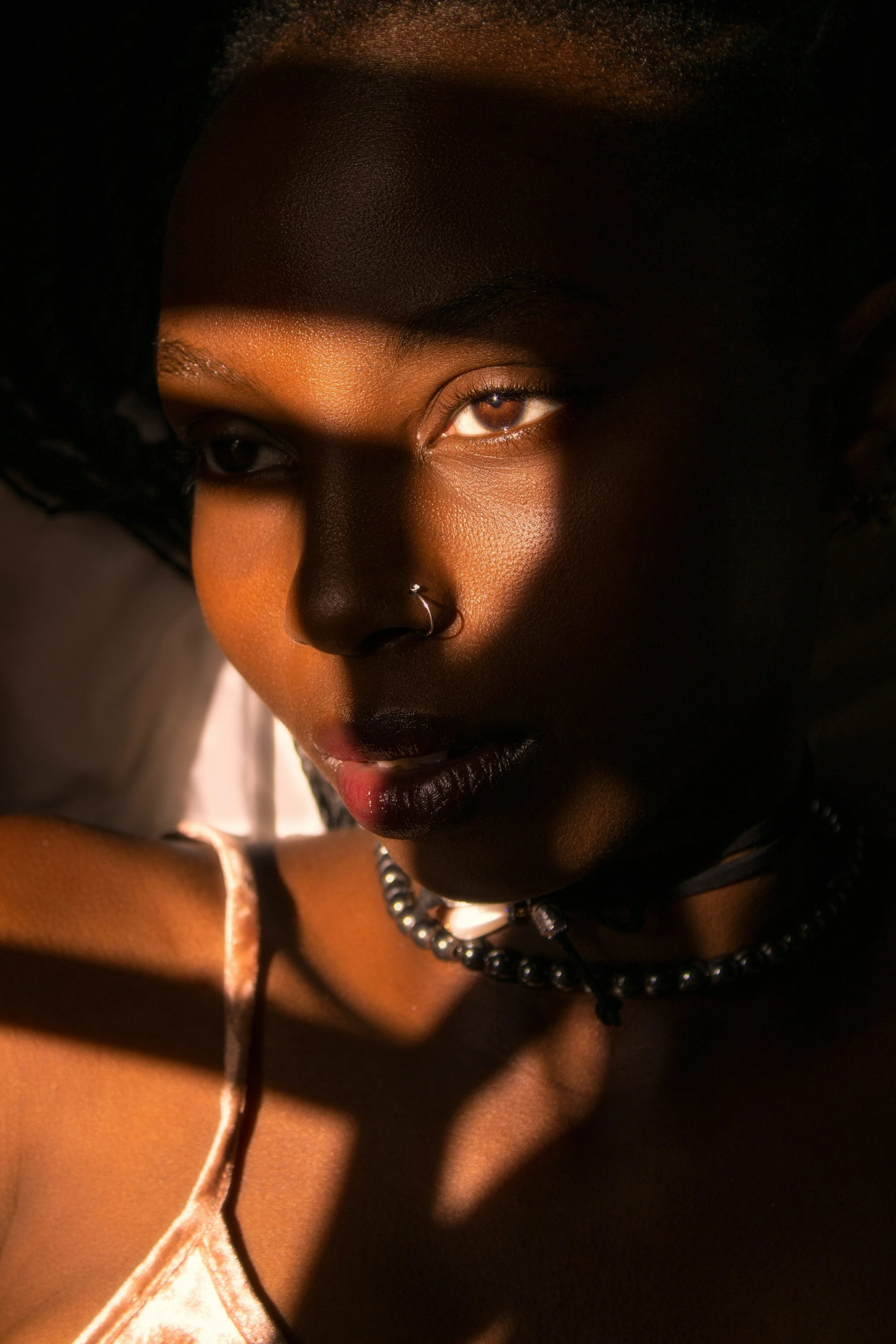 Close-up portrait of a woman with radiant skin in dramatic light — chemical peel treatments at Skinor, Chelsea SW3