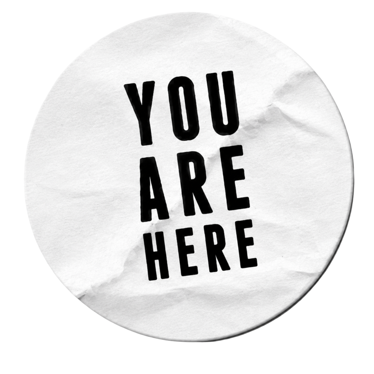 A crumpled piece of paper with the words 'YOU ARE HERE' printed in bold black letters.