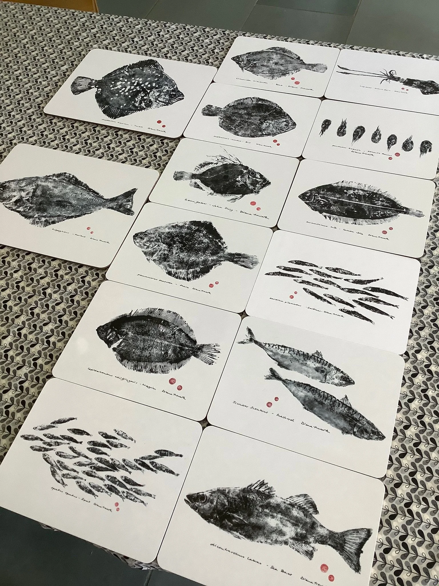 A collection of black and white table mats of various fish.