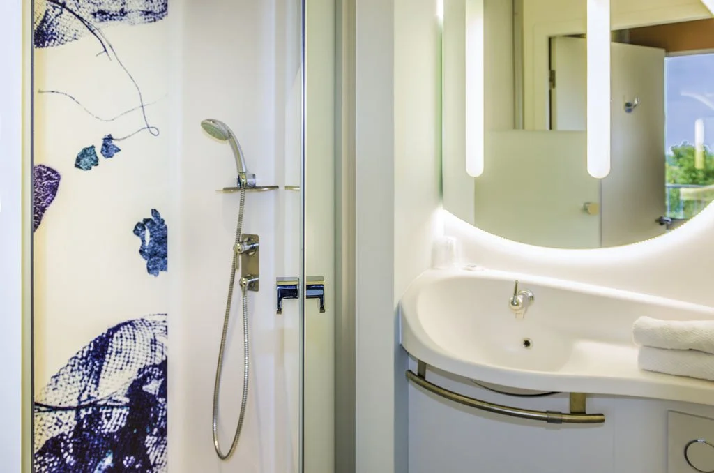 Salle de bain moderne avec douche et grand miroir lumineux