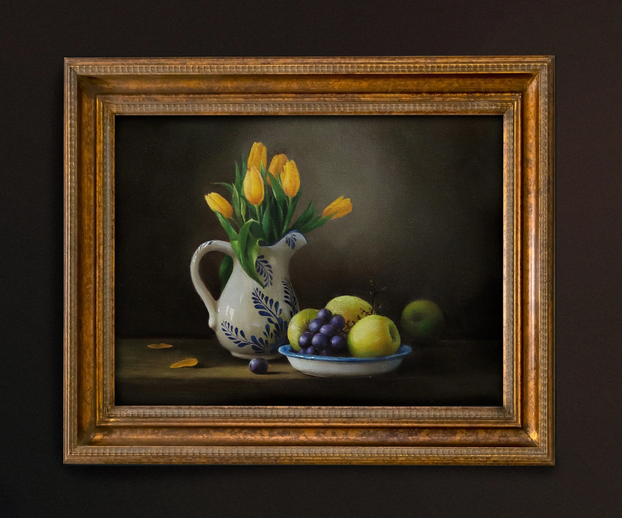Painting of a white vase with yellow tulips and green leaves, with a plate of green apples and purple grapes in the foreground, set against a dark background.