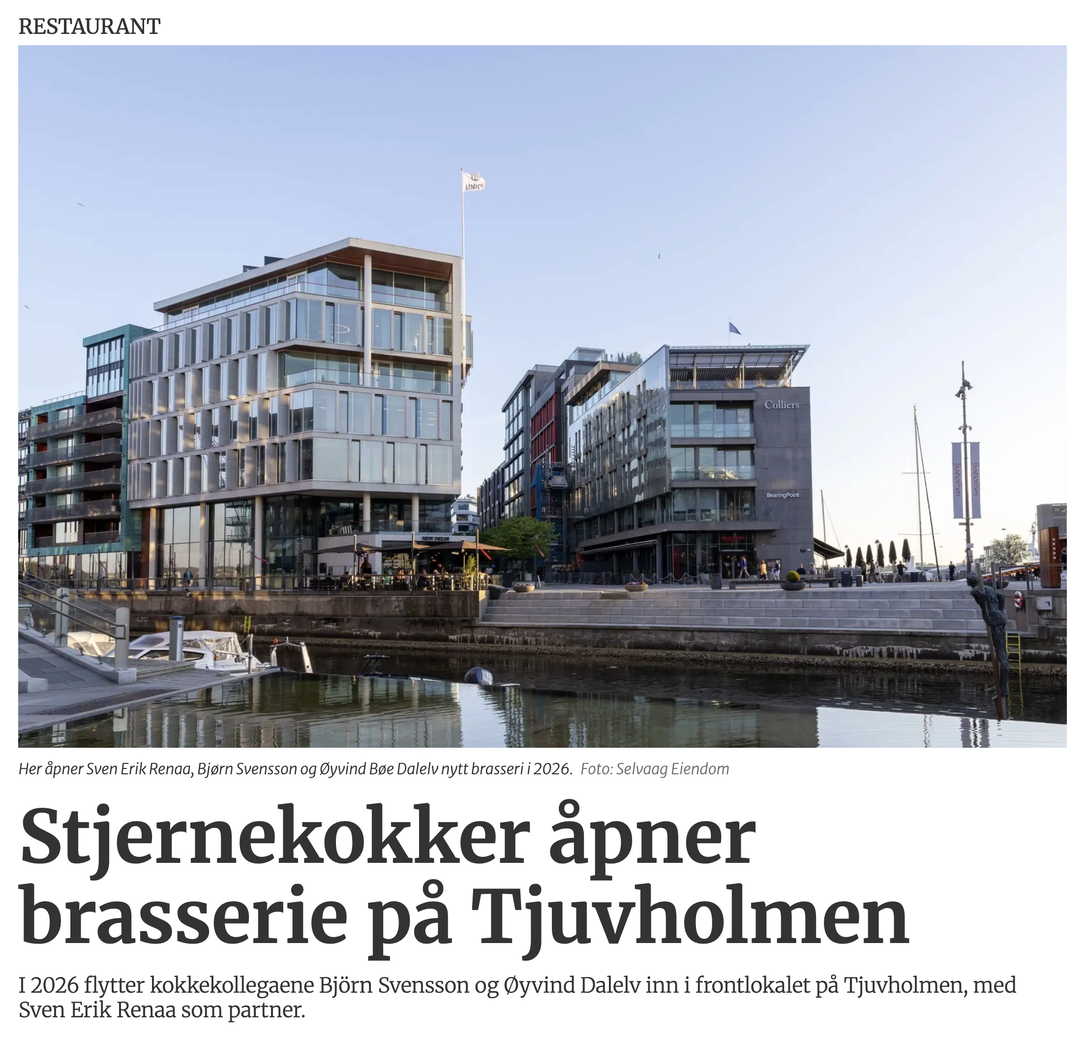 Photo of modern multi-story buildings next to water with boats docked along the quay; clear sky.