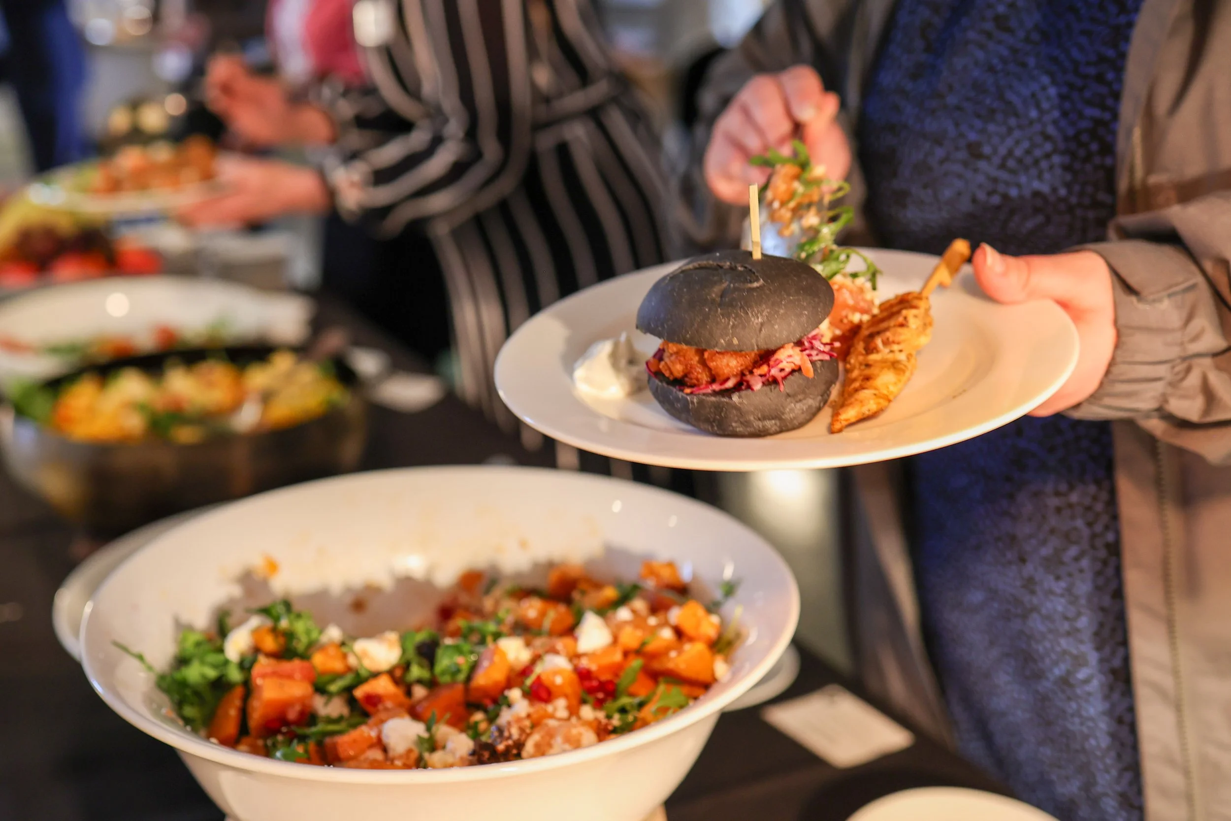 Guests are enjoying a vibrant buffet-style dining experience, featuring colourful seasonal dishes and relaxed social dining in an event.